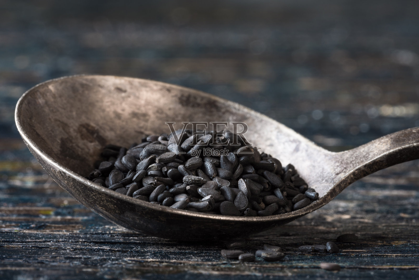木桌上旧匙中的黑芝麻特写照片摄影图片