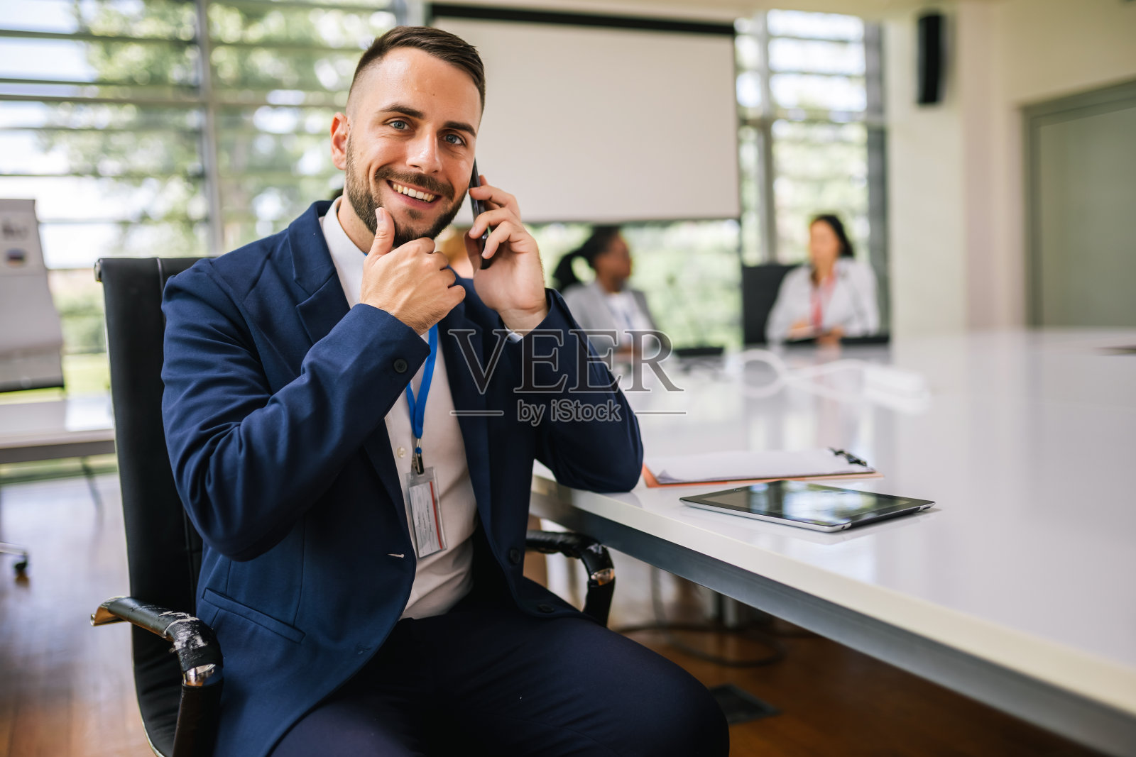 一幅商人的肖像，他坐在办公室里开会，正在打电话。照片摄影图片