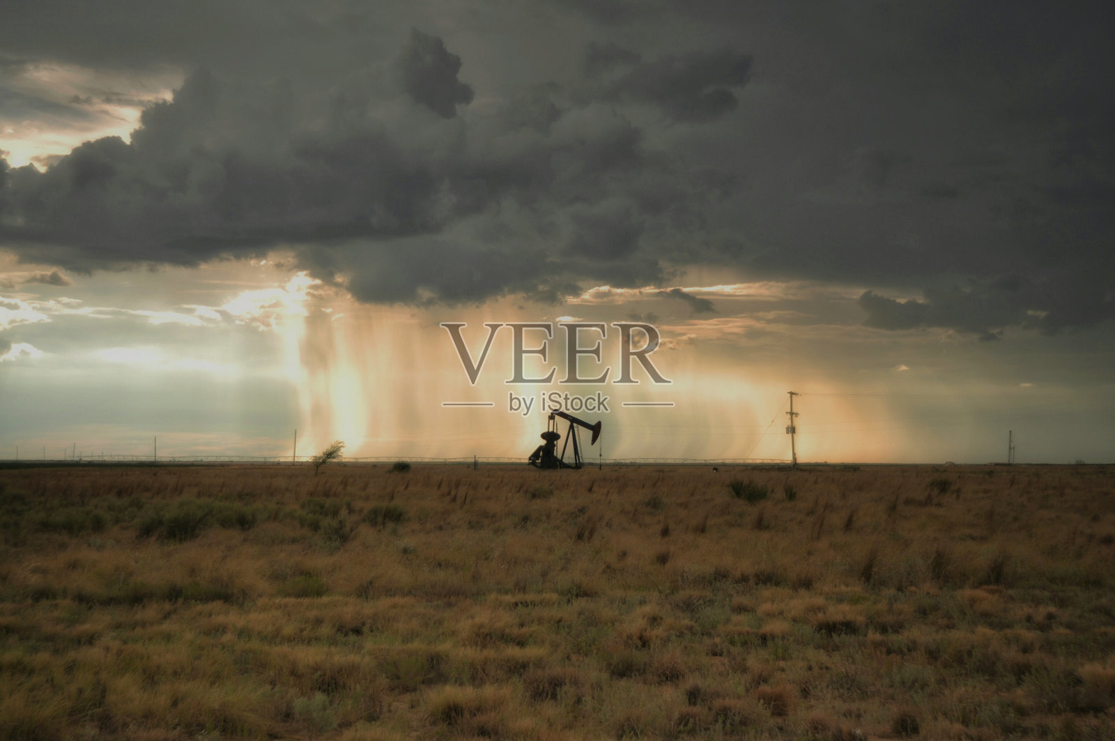 中距离的油田对多云的天空在日落照片摄影图片