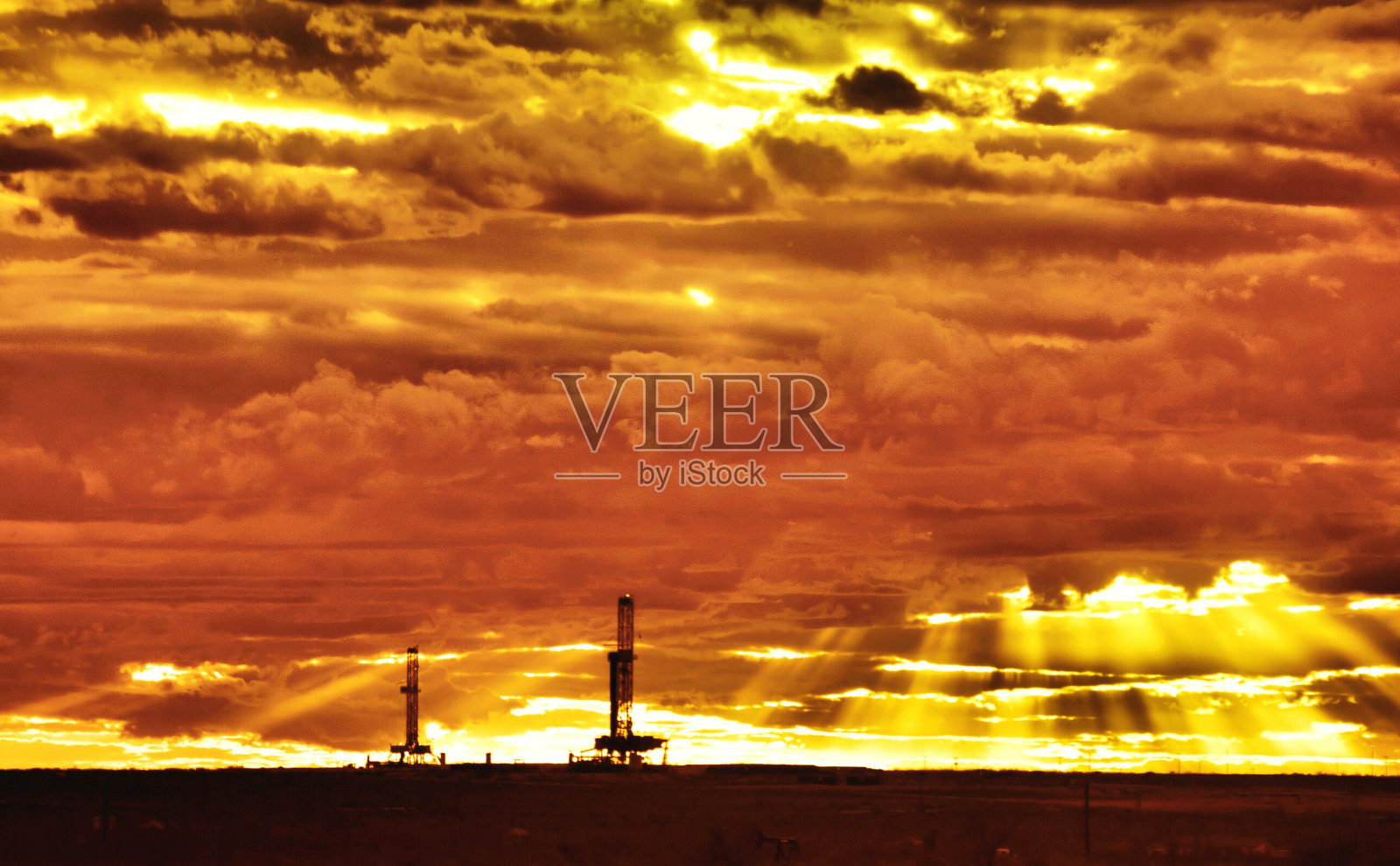 轮廓油泵对多云的天空在日落照片摄影图片