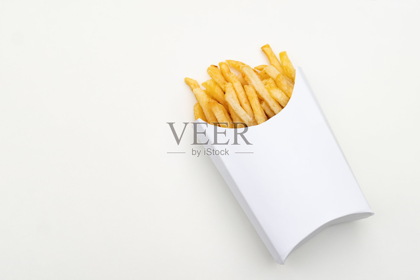 一份装在白色纸板箱里的薯条。白皮书的背景和包装照片摄影图片