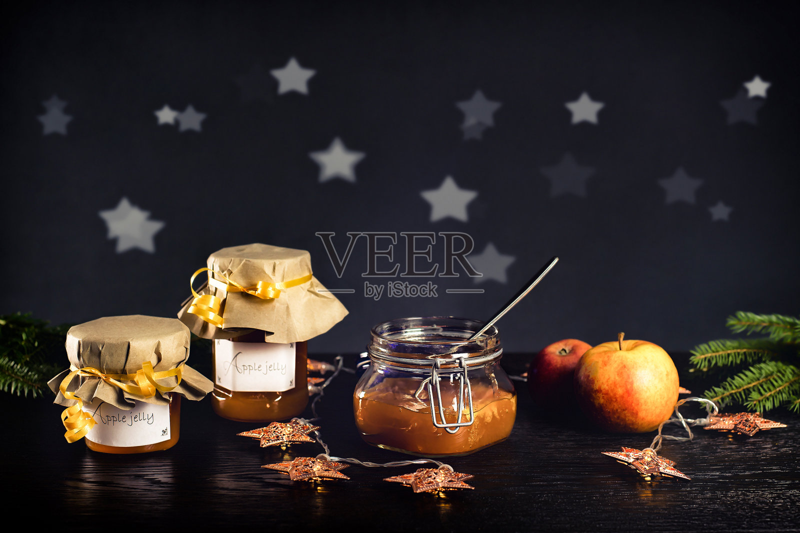 圣诞苹果果冻。一罐自制的苹果果冻在黑暗、喜庆的环境中摆着照片摄影图片