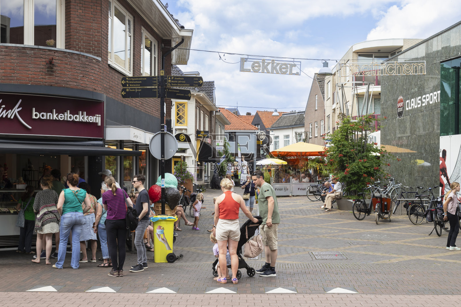 人们在Doetinchem一条令人愉快的购物街上排队等待一家冰淇淋店。照片摄影图片