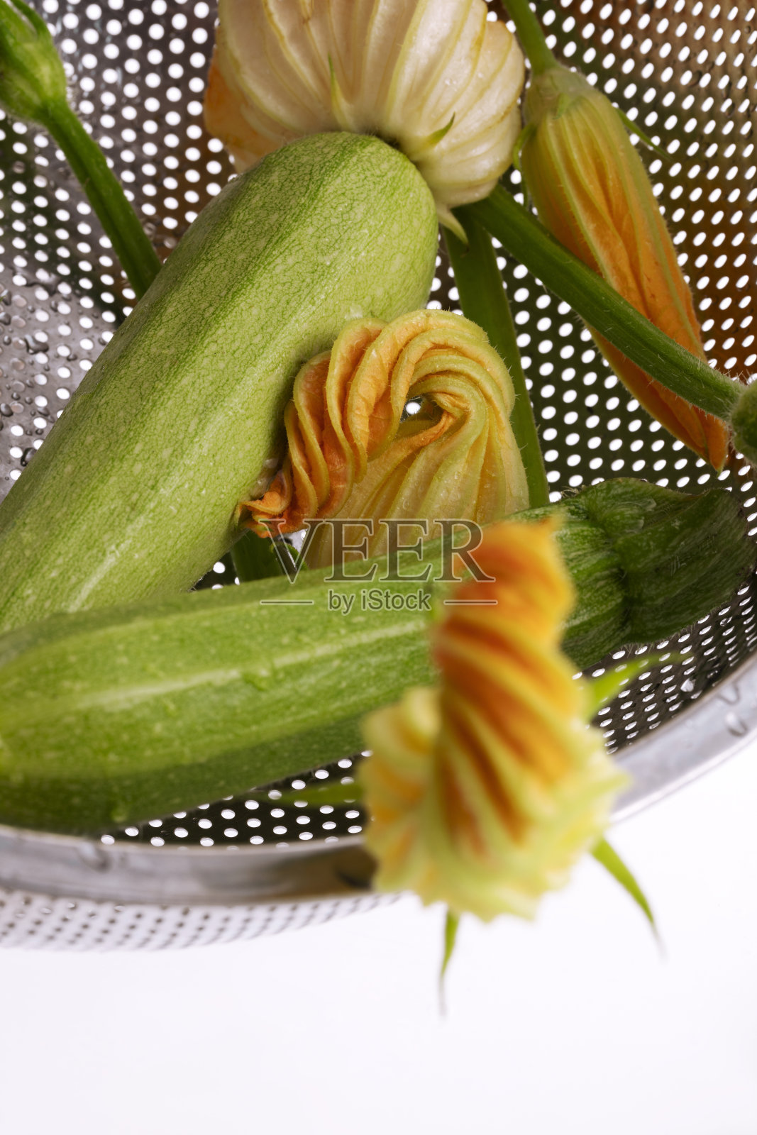 小西葫芦和西葫芦花放在金属滤锅里照片摄影图片