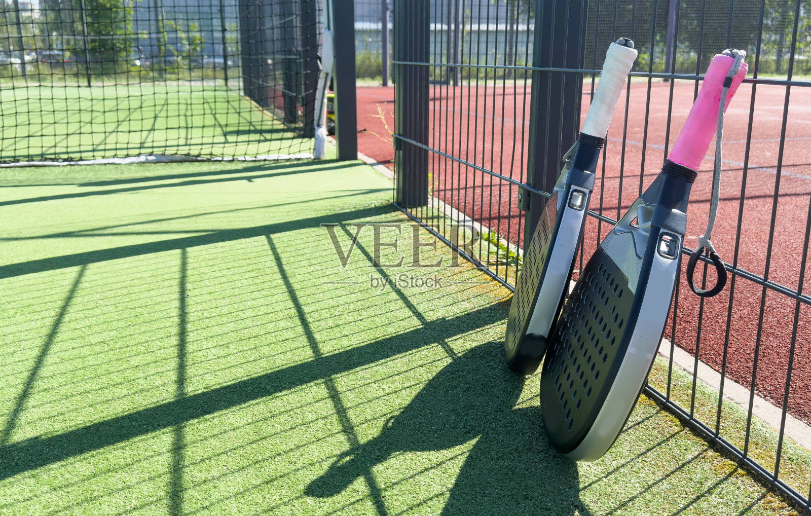 室外自然采光的绿色场地，网后的球拍附近的草皮上的黄色球。球拍是一种球拍游戏。专业的运动理念与文案空间。照片摄影图片