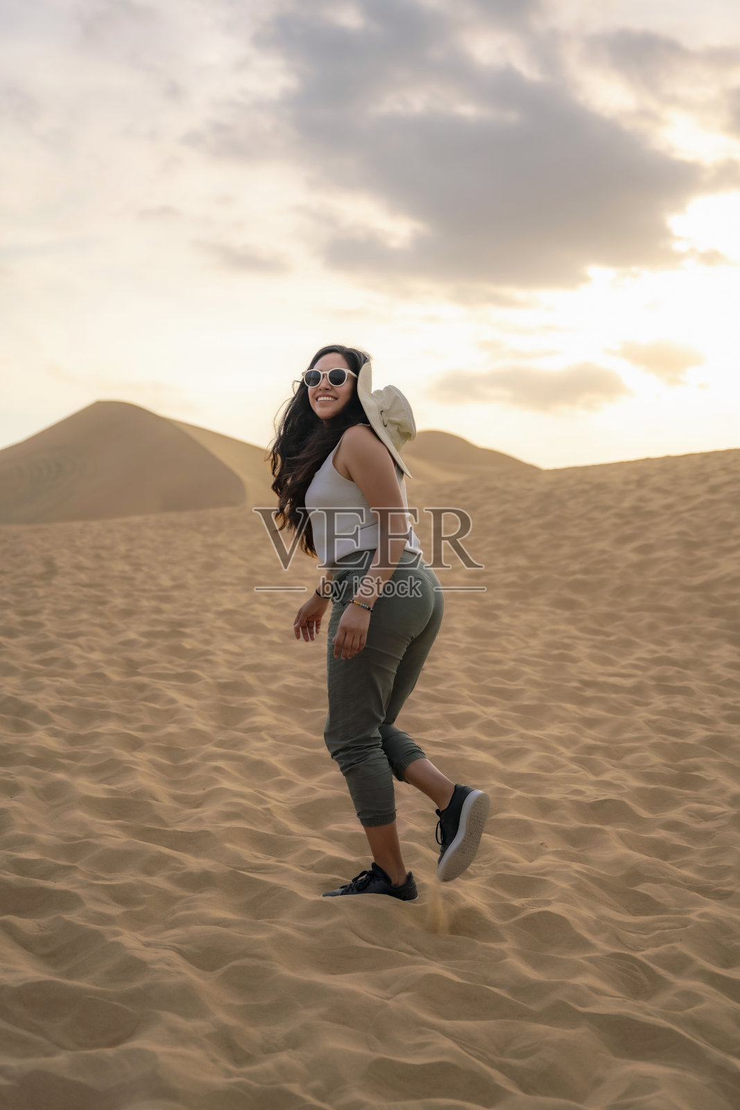 在华卡奇纳享受沙丘的年轻女子照片摄影图片