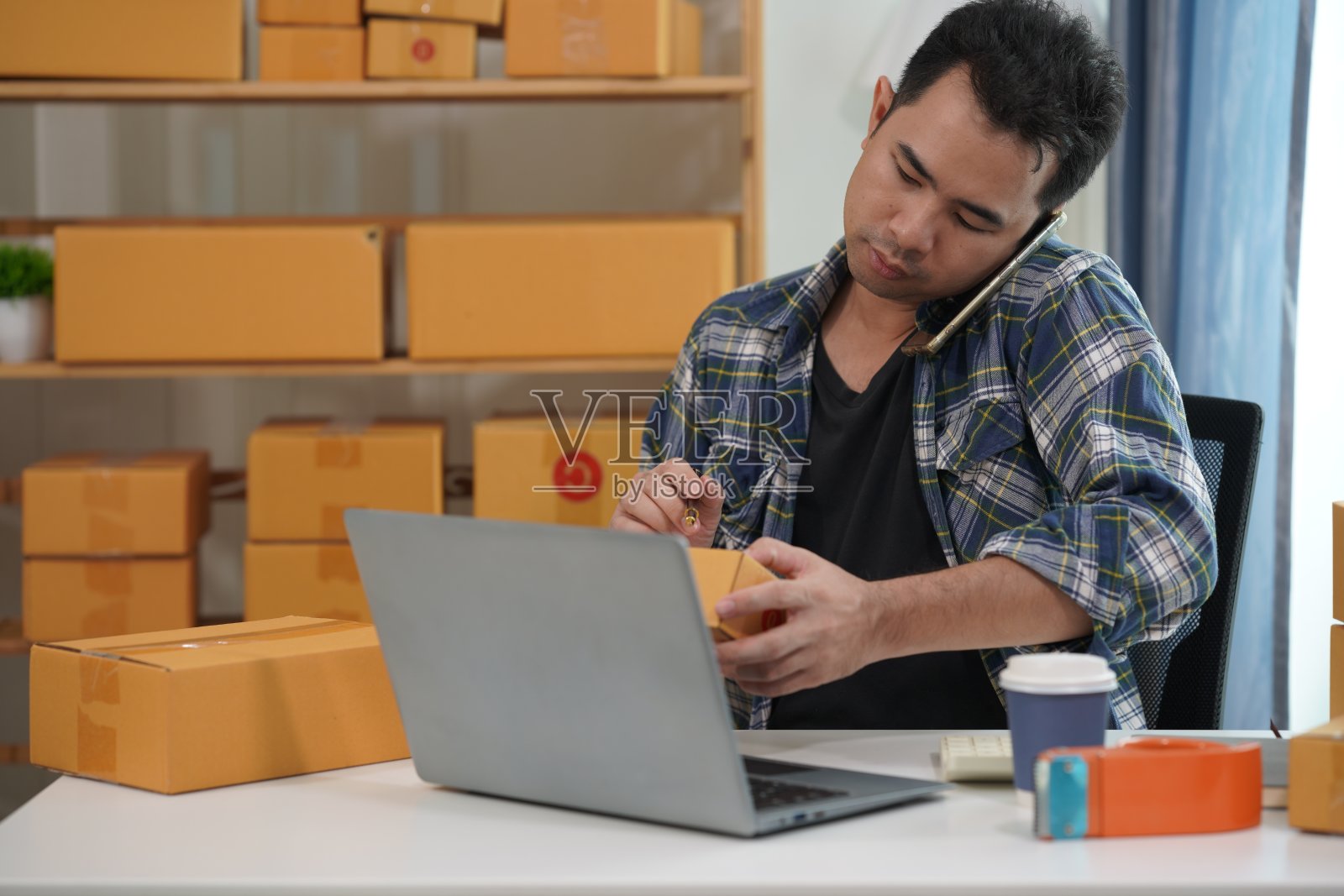 在网站和网络平台销售产品的亚洲男性企业主通过快递服务向客户销售产品并将产品包装成包裹盒，中小企业业务照片摄影图片