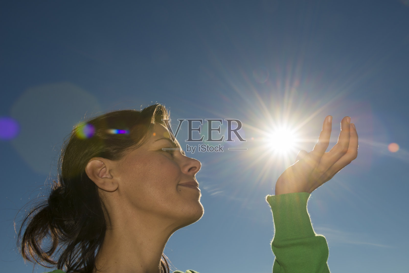 年轻女子对着太阳的低角度视角照片摄影图片