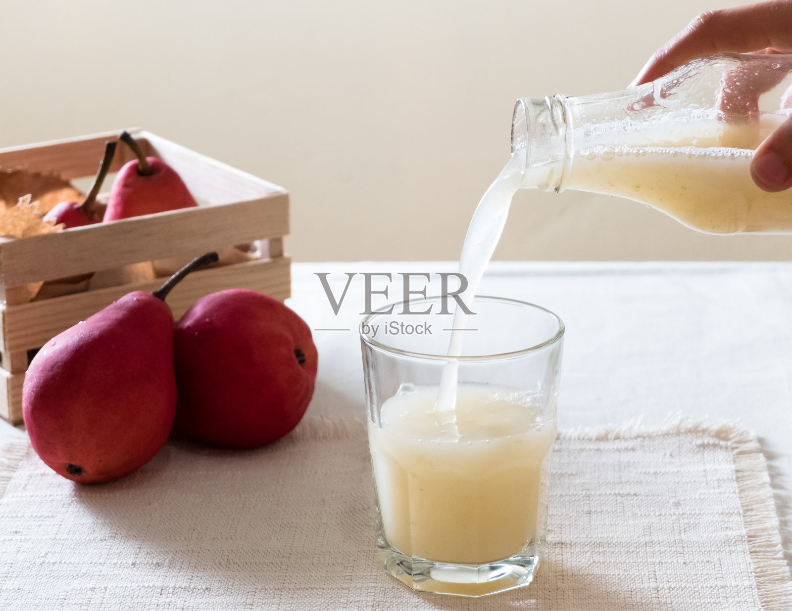 裁剪图像的手倒饮料在杯子上的桌子上照片摄影图片