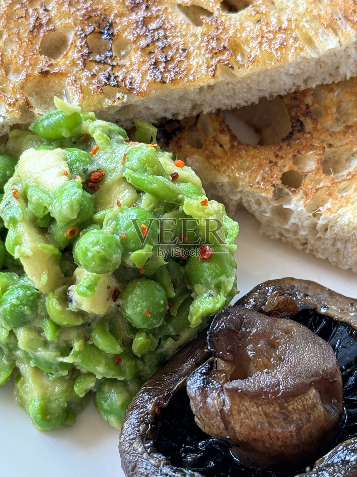 全画幅图像盘煎早餐食材，鳄梨和薄荷豌豆泥，波多贝罗蘑菇，酵母吐司，高架视图，重点在前景照片摄影图片