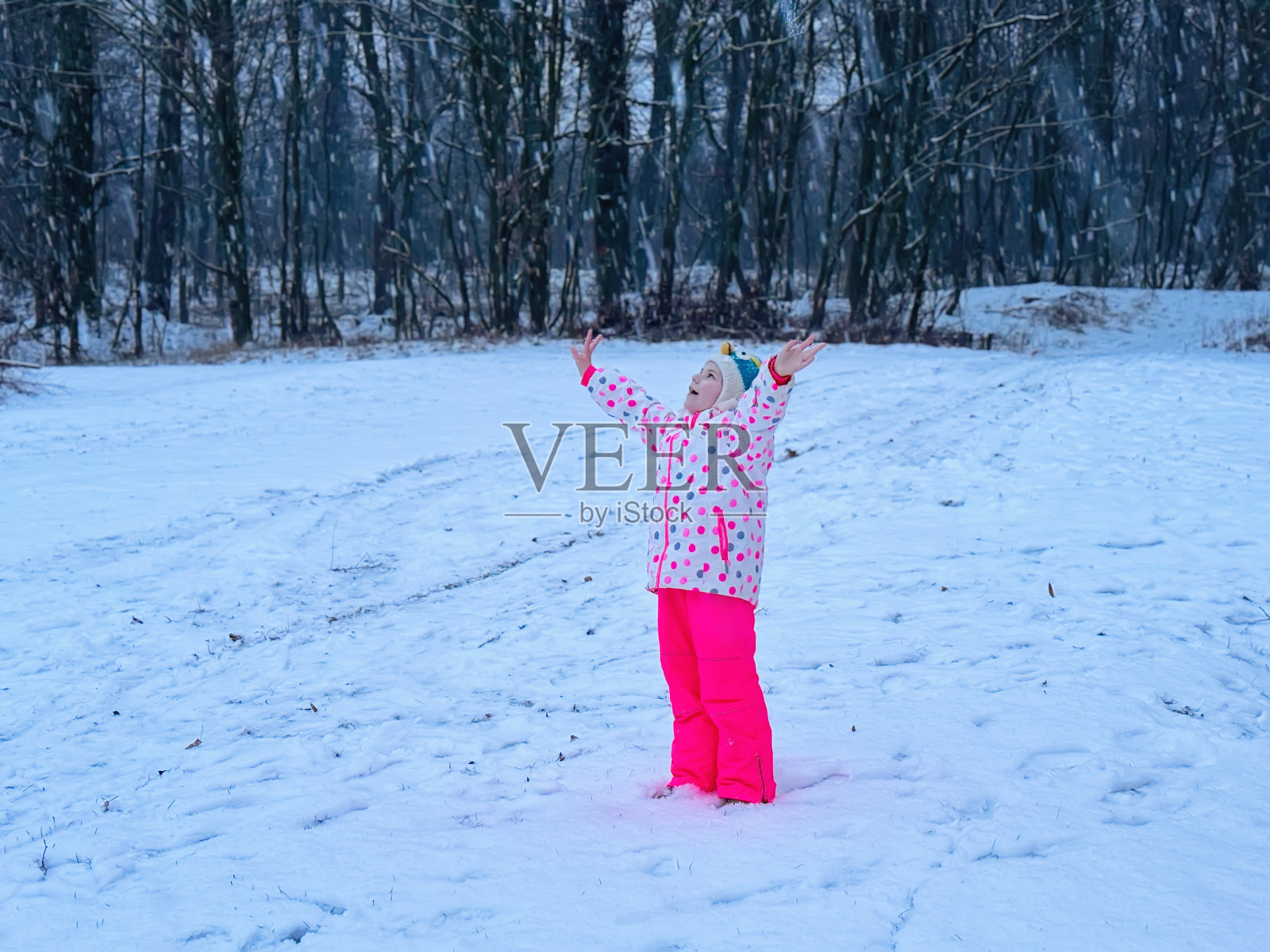 有趣的小女孩在美丽的冬季公园玩耍。快乐的孩子在学校里玩雪，快乐的谈论下雪和冬天的活动。照片摄影图片
