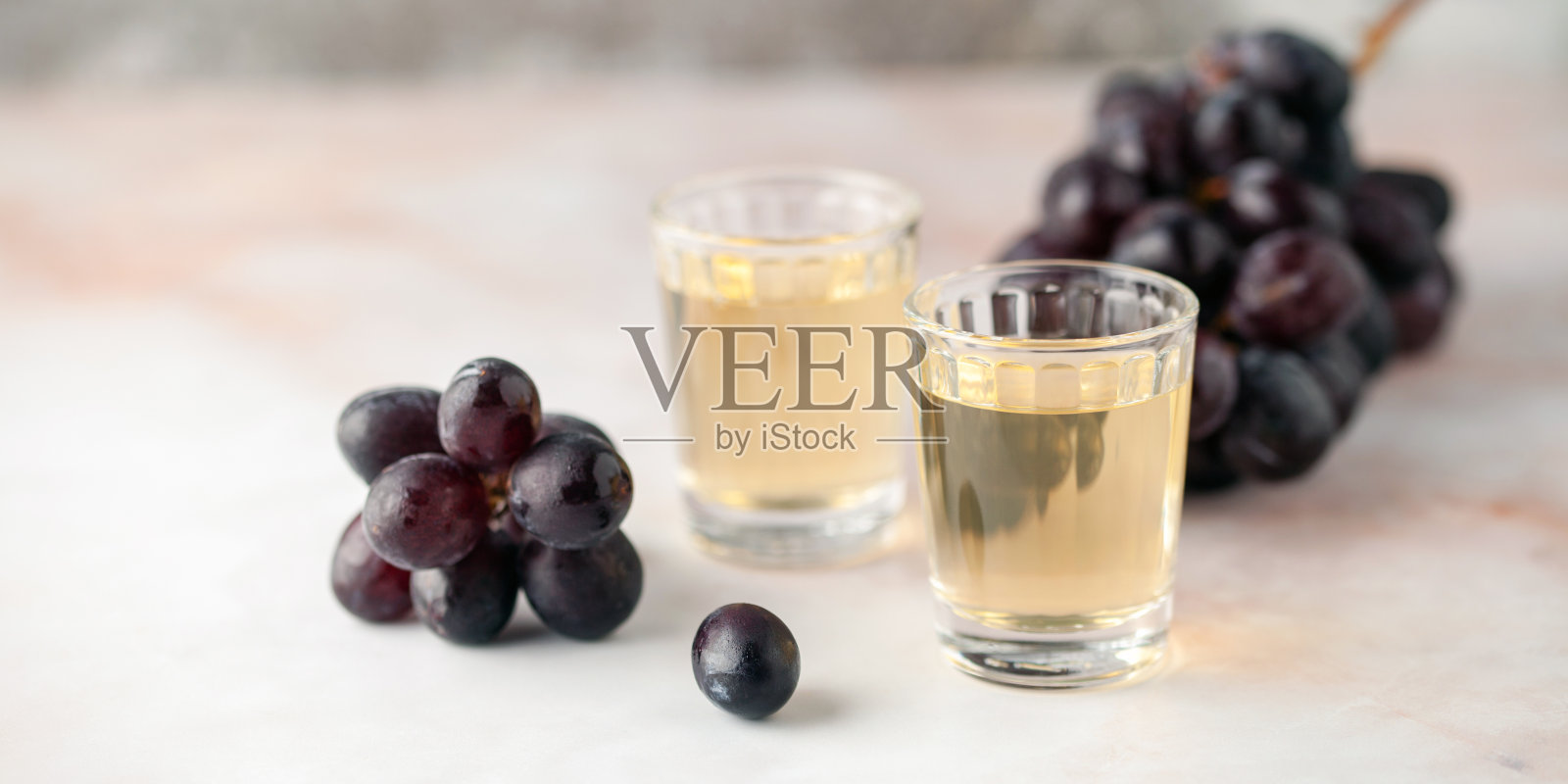 传统的格鲁吉亚恰恰，也被称为葡萄伏特加或格鲁吉亚格拉巴在小玻璃杯和新鲜葡萄照片摄影图片