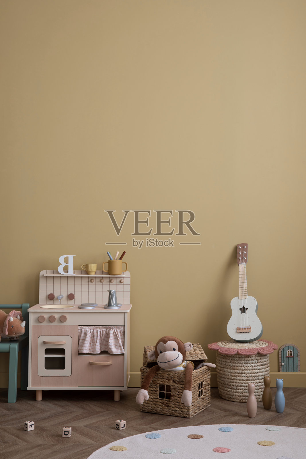 极简主义的儿童房室内组成，黄色的墙壁，儿童厨房，吉他，时尚的长凳，毛绒猴子，圆形地毯，木块和个人配件。家居装饰。模板。照片摄影图片