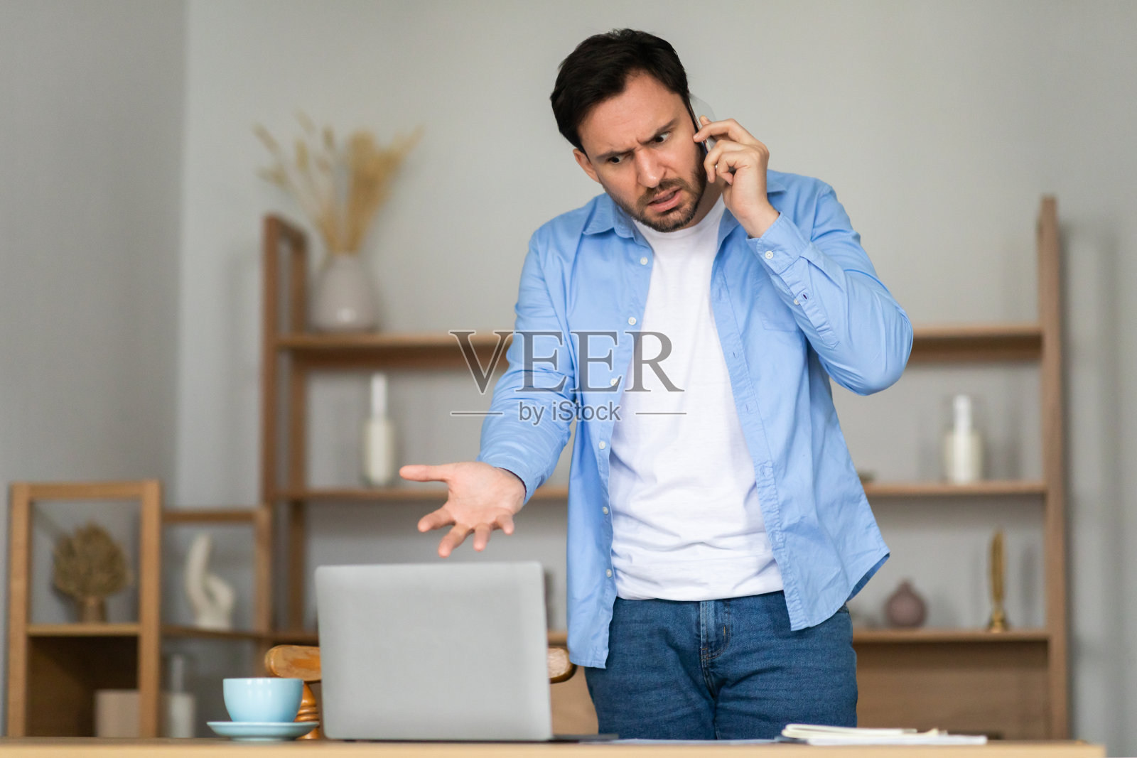 沮丧的男人在电话里进行激烈的交谈照片摄影图片