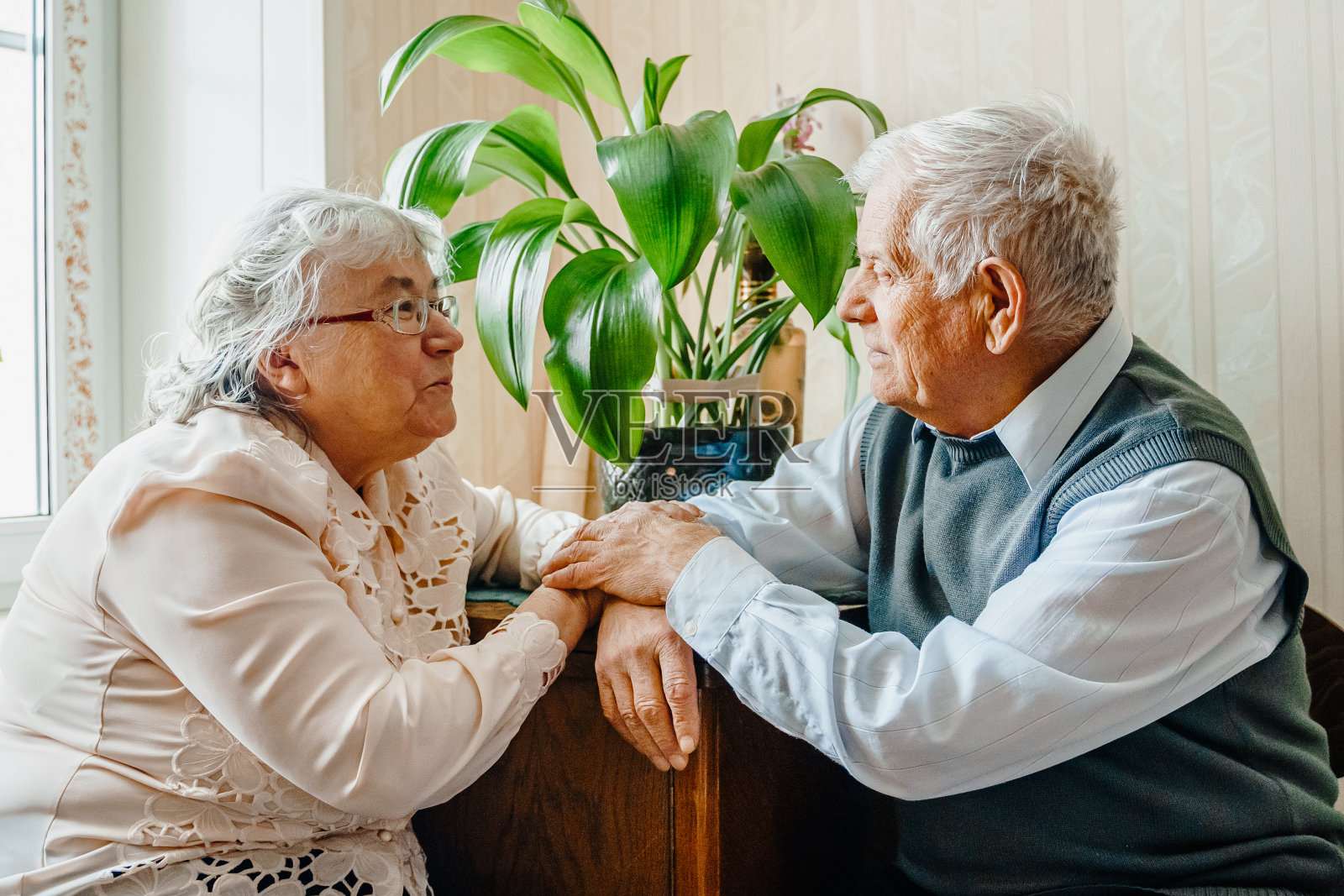 老年高级情侣浪漫爱情。老退休的男人女人在一起。年迈的丈夫和妻子穿着舒适的家毛衣。老人拥抱亲吻老人。阖家幸福长寿。温柔的感情关系照片摄影图片