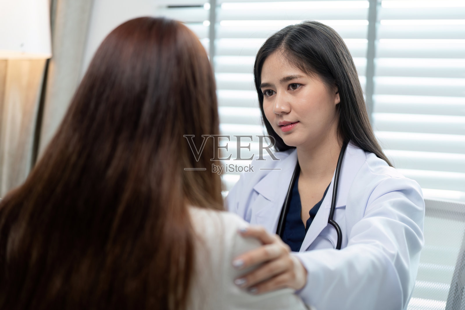 现代医务室中富有同情心的医生为病人进行健康检查和诊断照片摄影图片