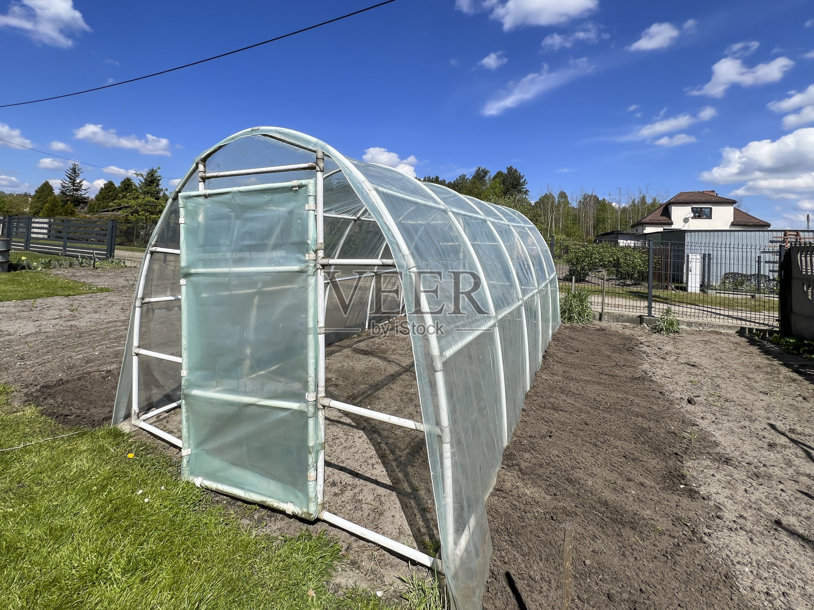 春天在框架上放上锡箔，在家里的菜园里搭上锡箔帐篷照片摄影图片