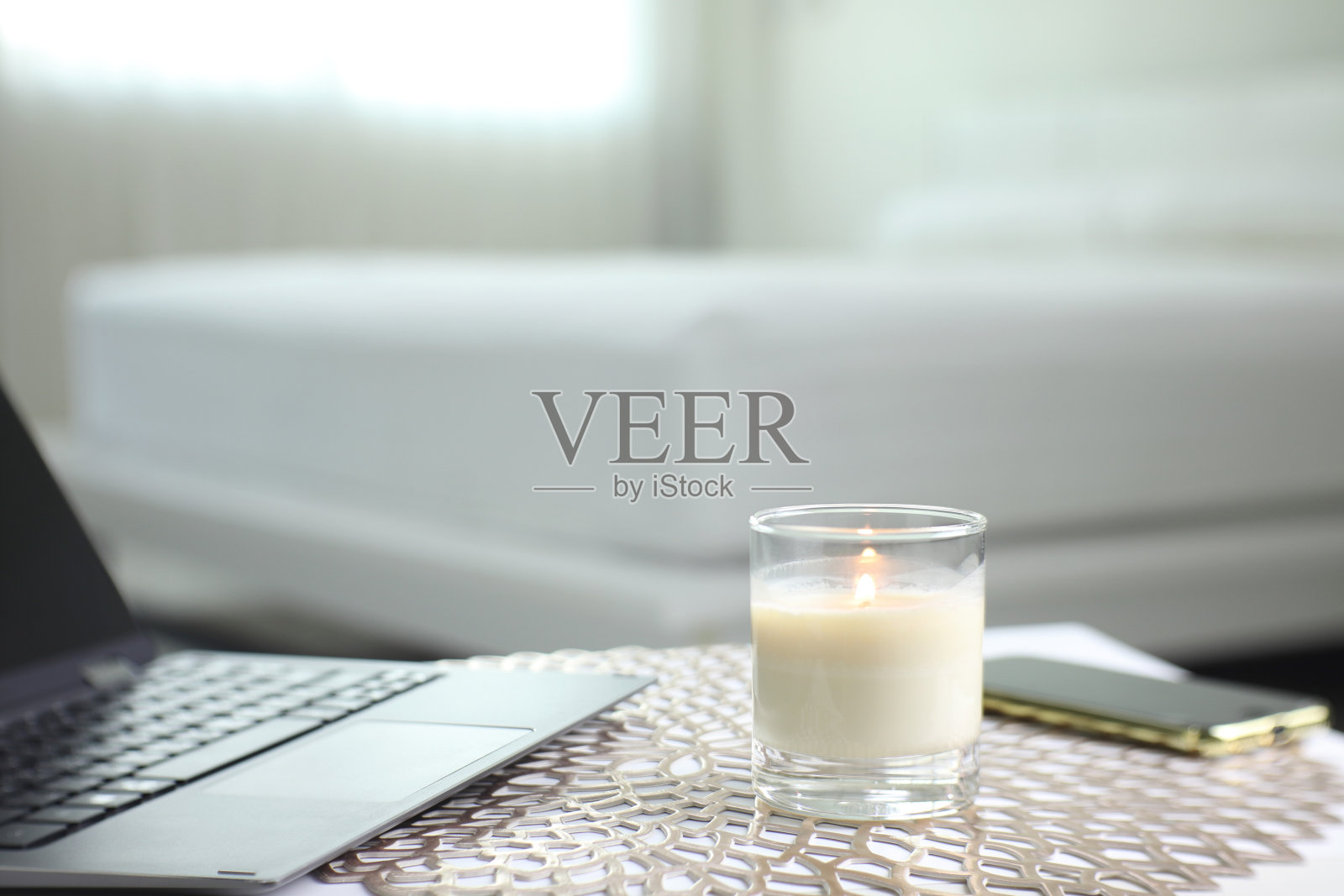 白色卧室里漂亮的桌子上的豪华香薰蜡烛创造了放松的环境照片摄影图片