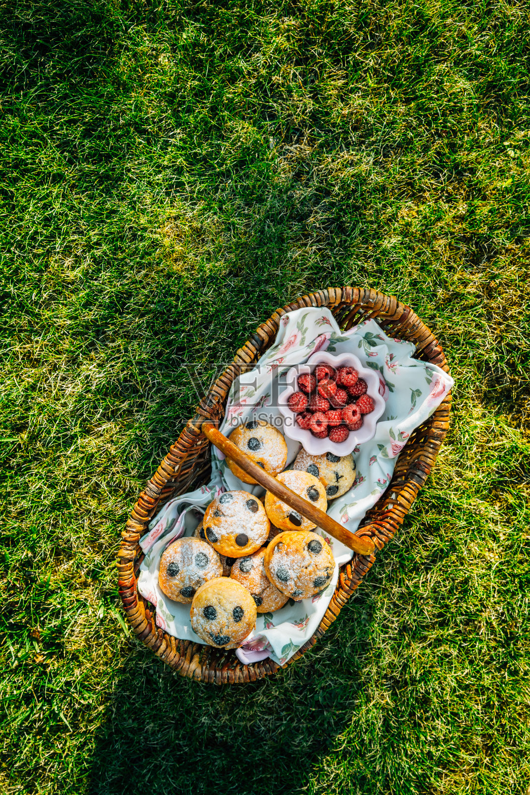自制的松饼和浆果放在野餐篮里，放在有复印空间的草地上照片摄影图片
