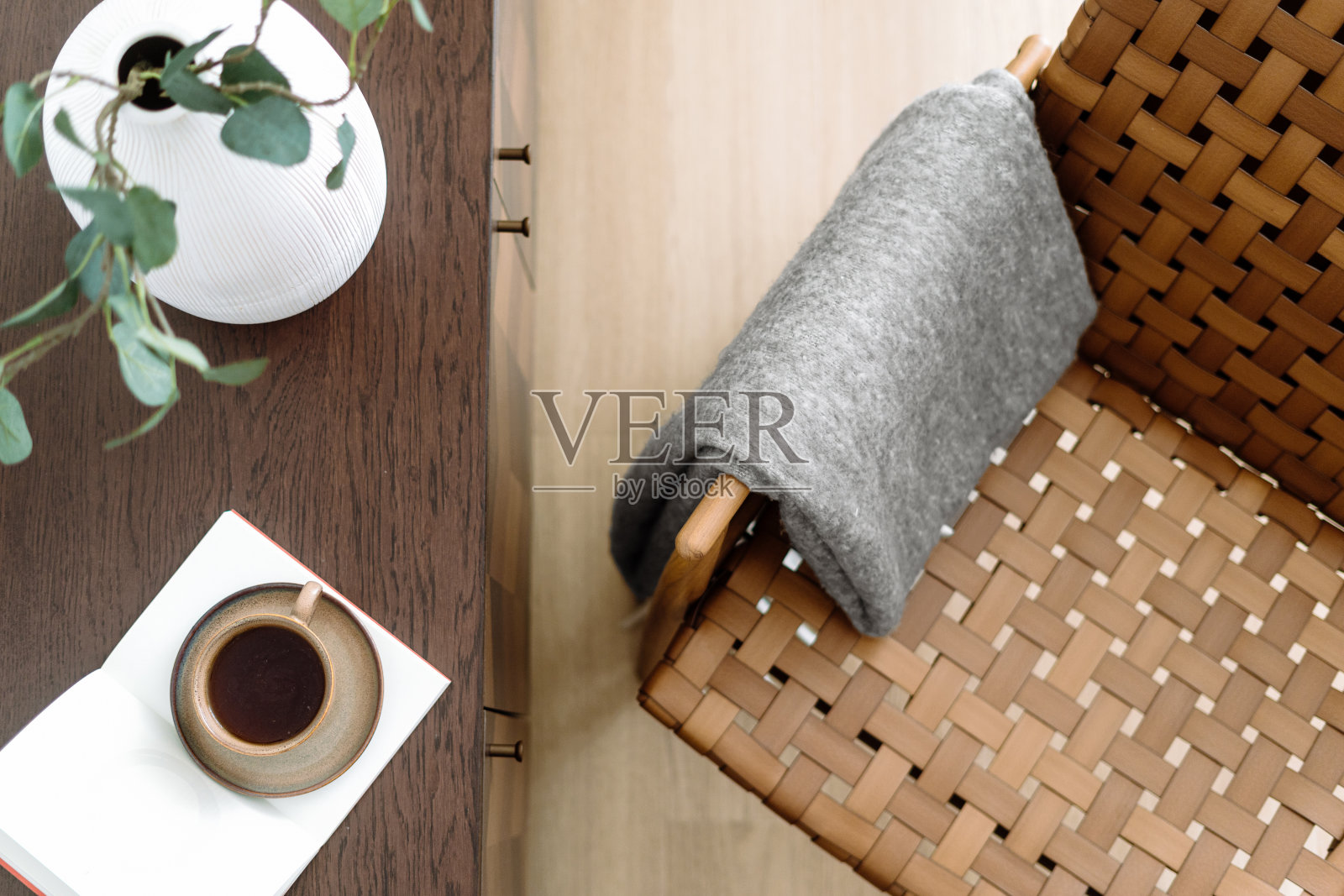 藤椅靠近木桌，上面放着打开的书和咖啡杯照片摄影图片