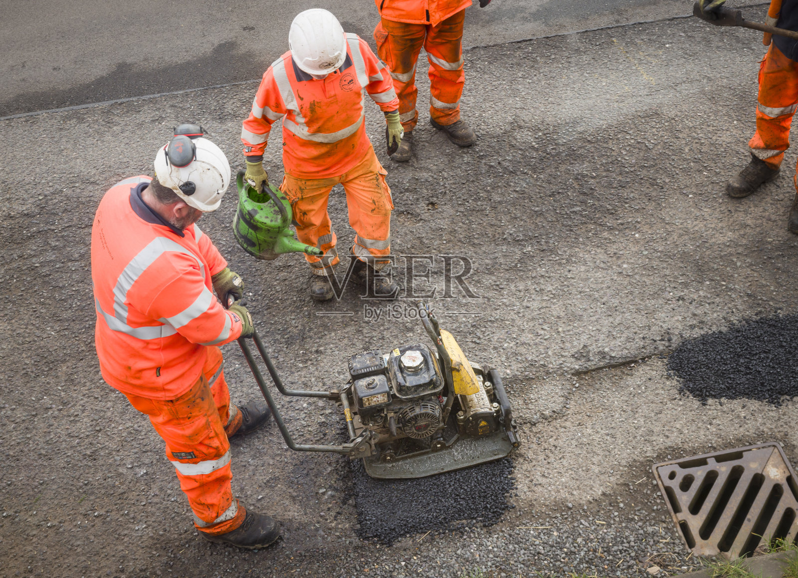 修路工人正在修理英国乡间道路上的坑洼照片摄影图片