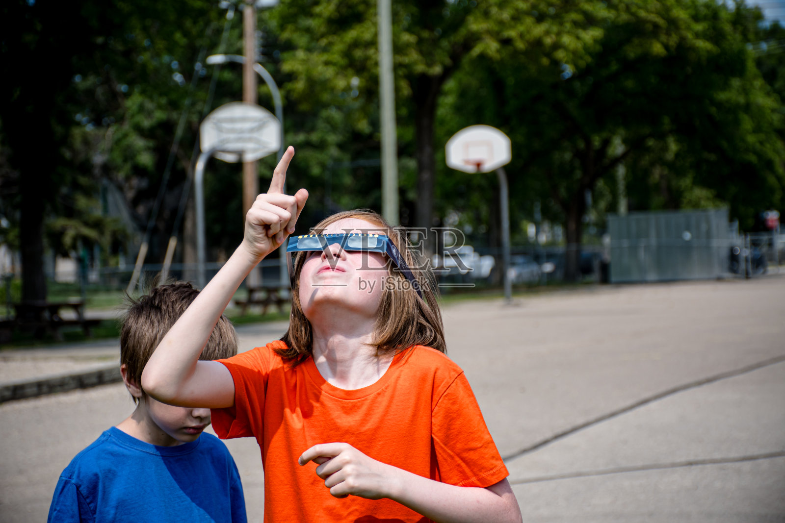 非双星孩子和兄弟用特殊的眼镜观看日食照片摄影图片