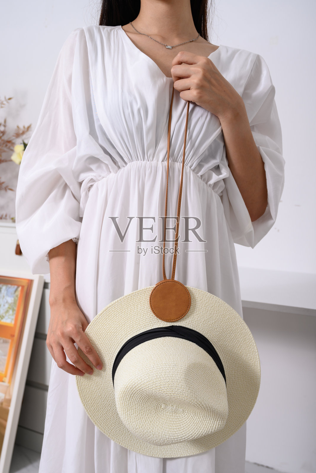 优雅的女人穿着白色连衣裙，戴着草帽，生活方式的照片照片摄影图片