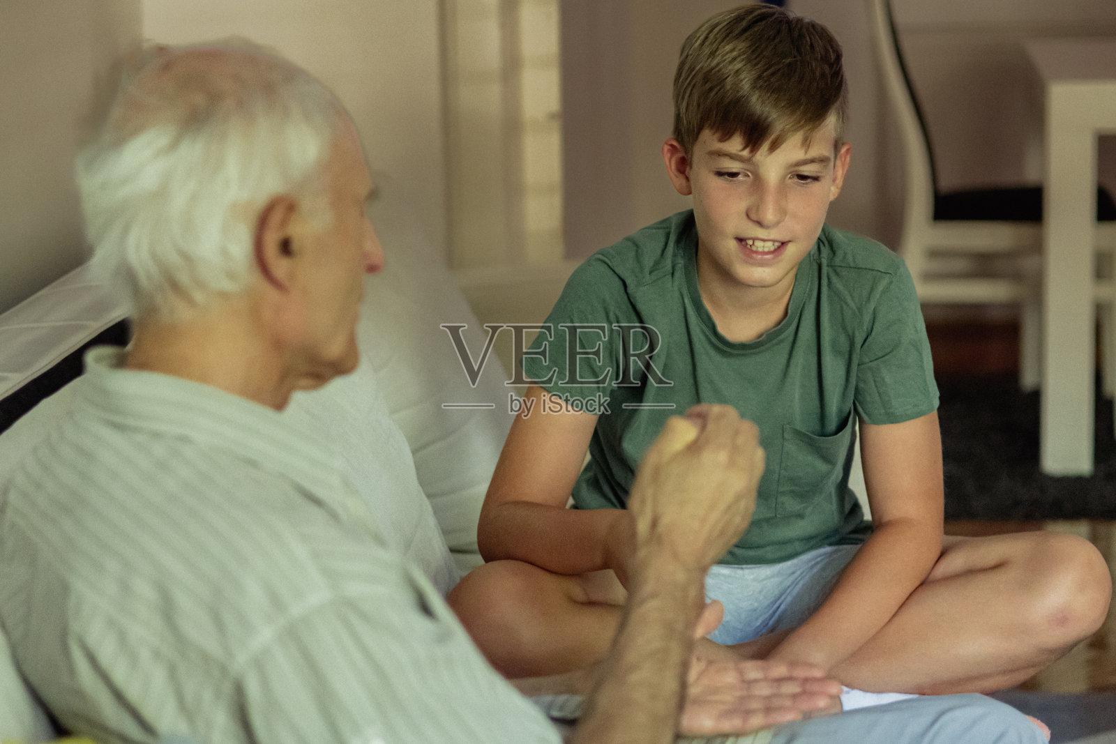 Grandfatherhood。快乐的爷爷和孙子在客厅里玩石头、剪刀布。照片摄影图片