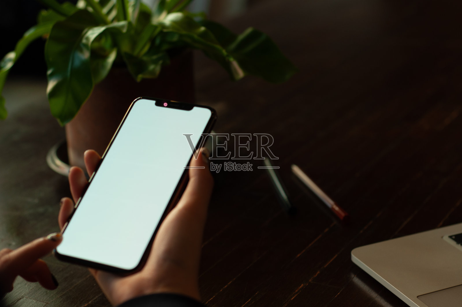 在桌子上使用手机的手特写照片摄影图片