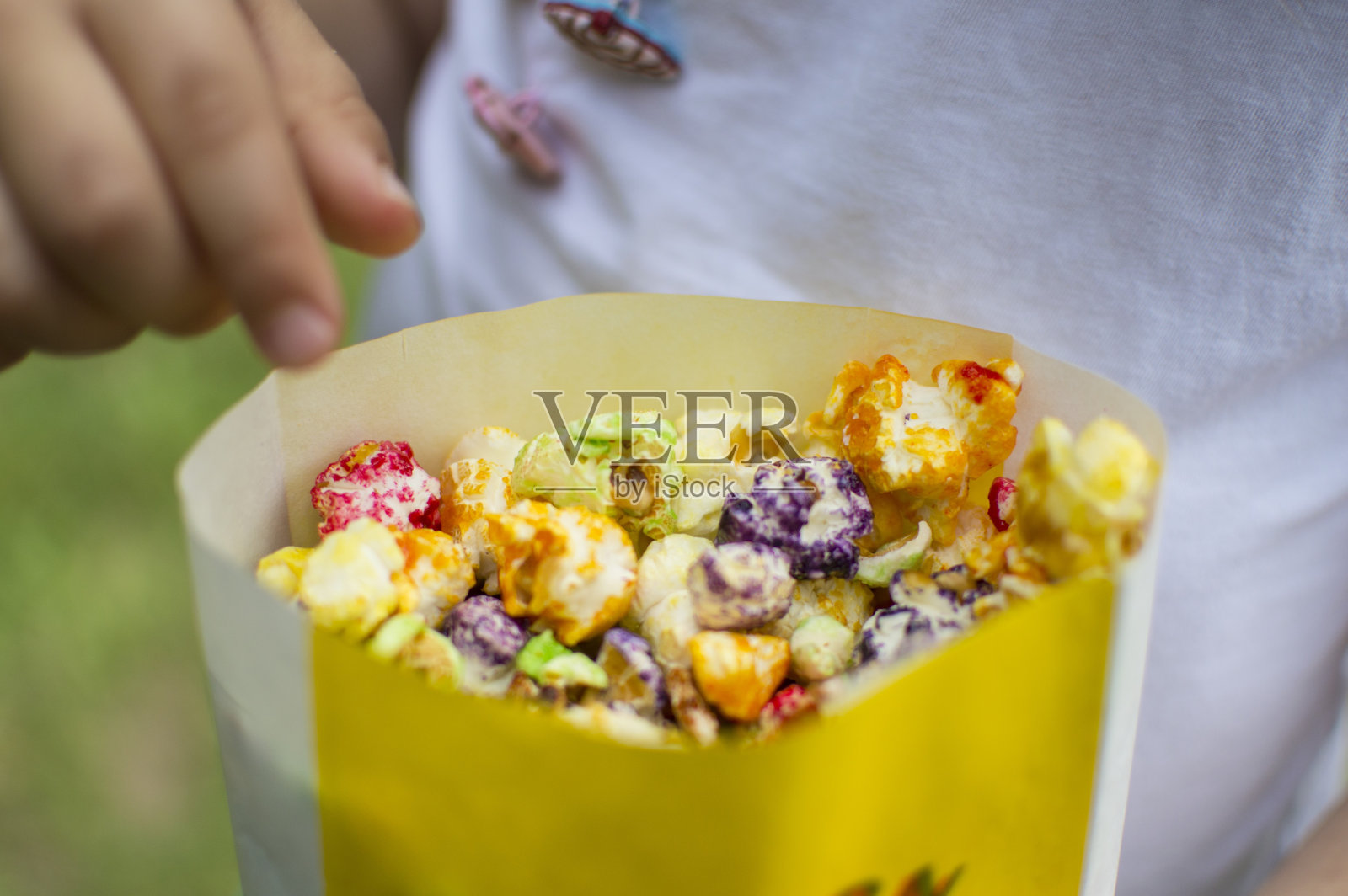 小朋友在吃五颜六色的美味爆米花照片摄影图片