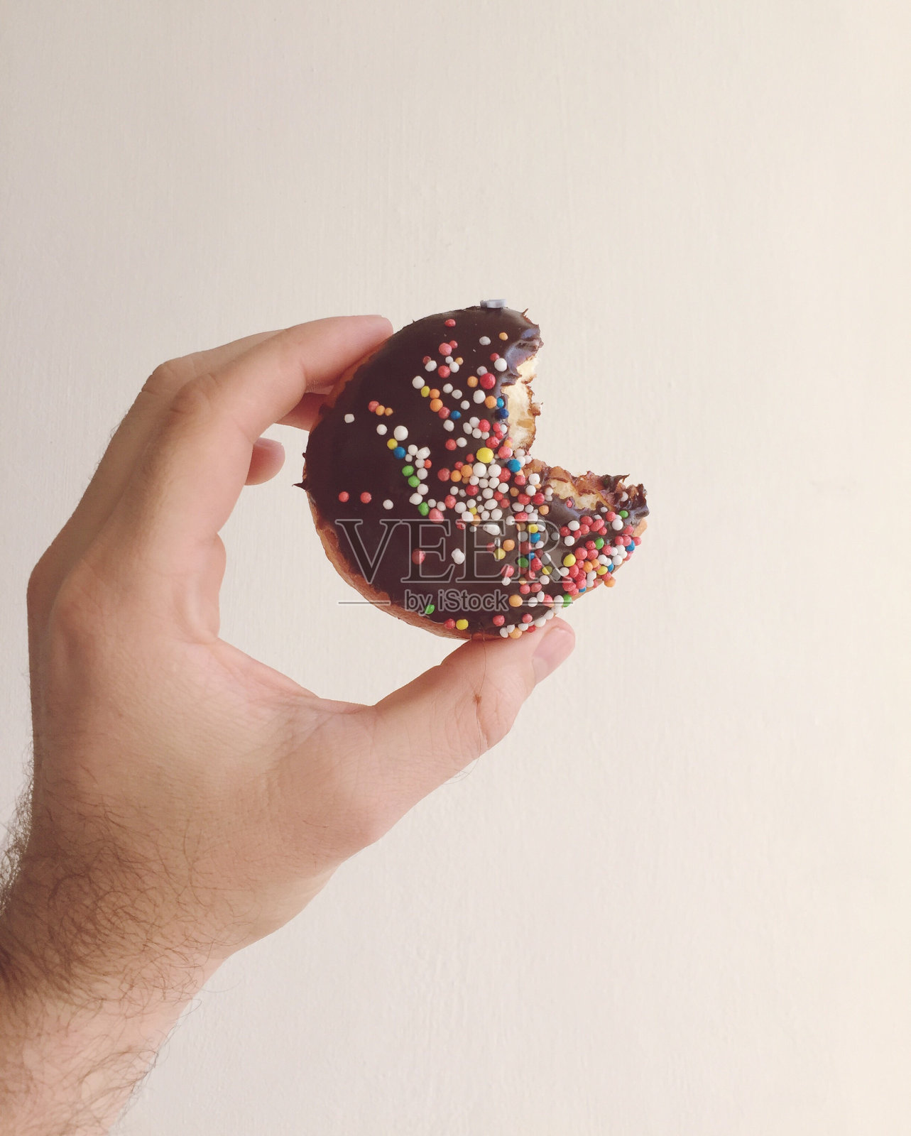 裁剪手的人拿着甜甜圈对白色背景照片摄影图片