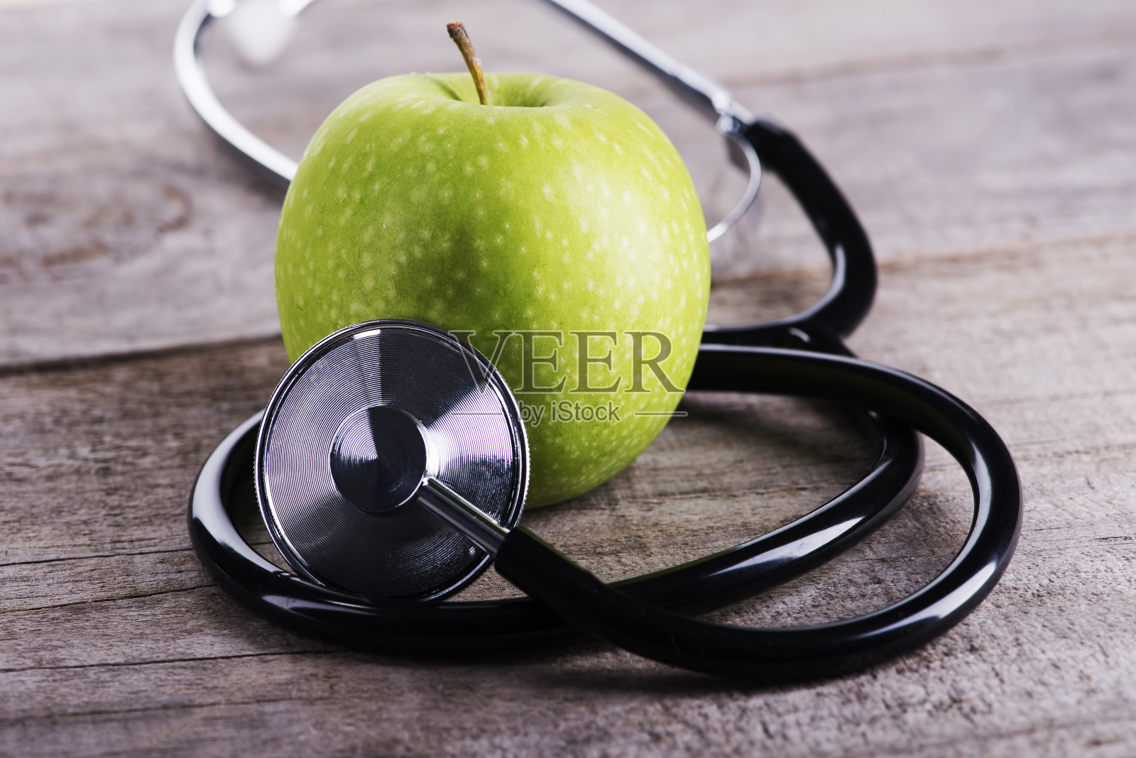 史密斯奶奶苹果的特写，听诊器放在桌子上照片摄影图片