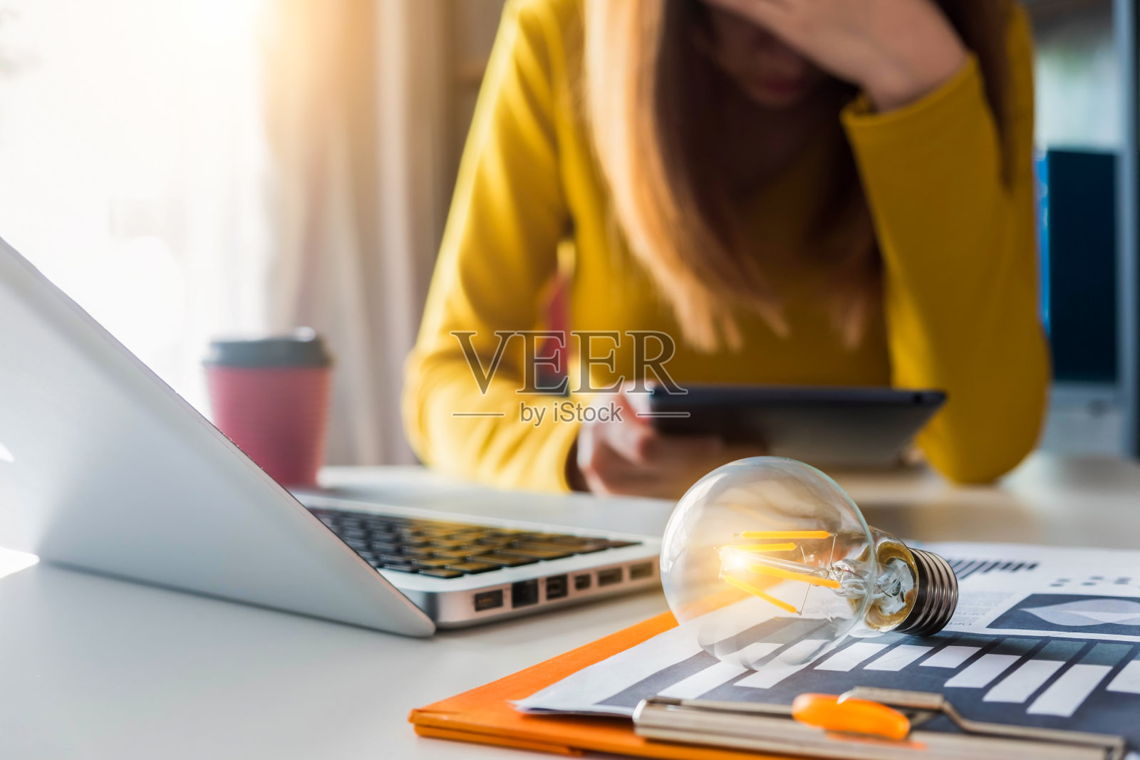 女商人的中间部分，桌上放着笔记本电脑和灯泡照片摄影图片