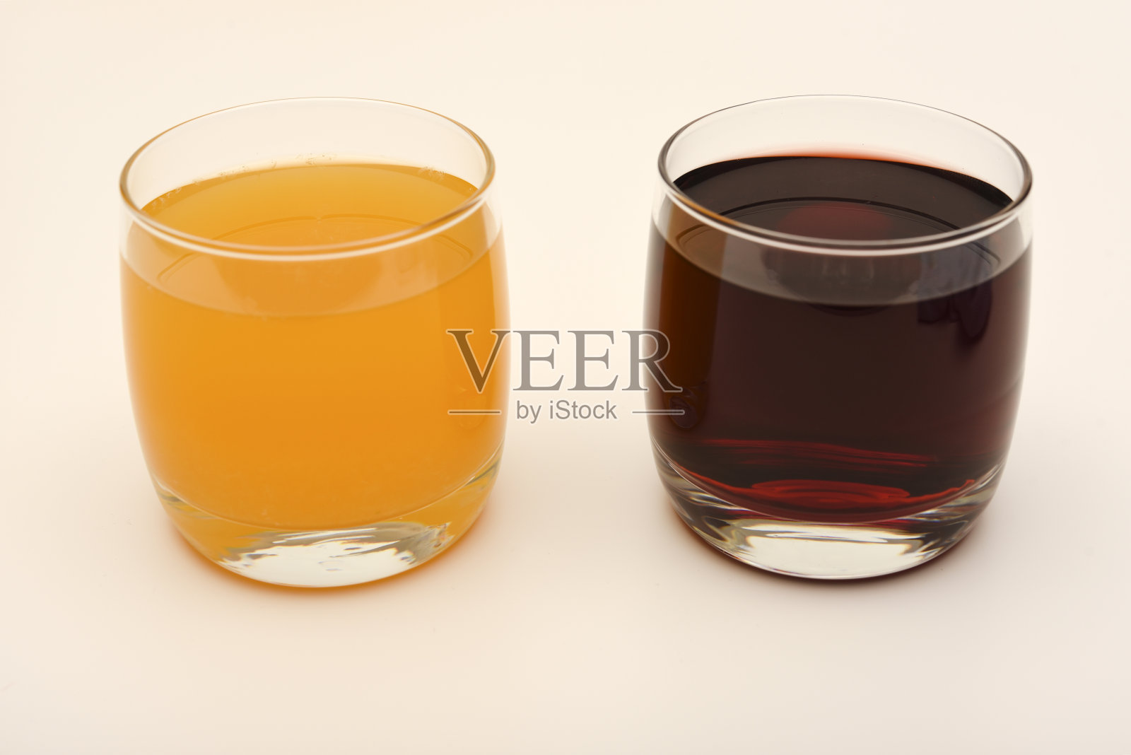 果汁装在白色背景的玻璃杯里。樱桃和橙汁。照片摄影图片