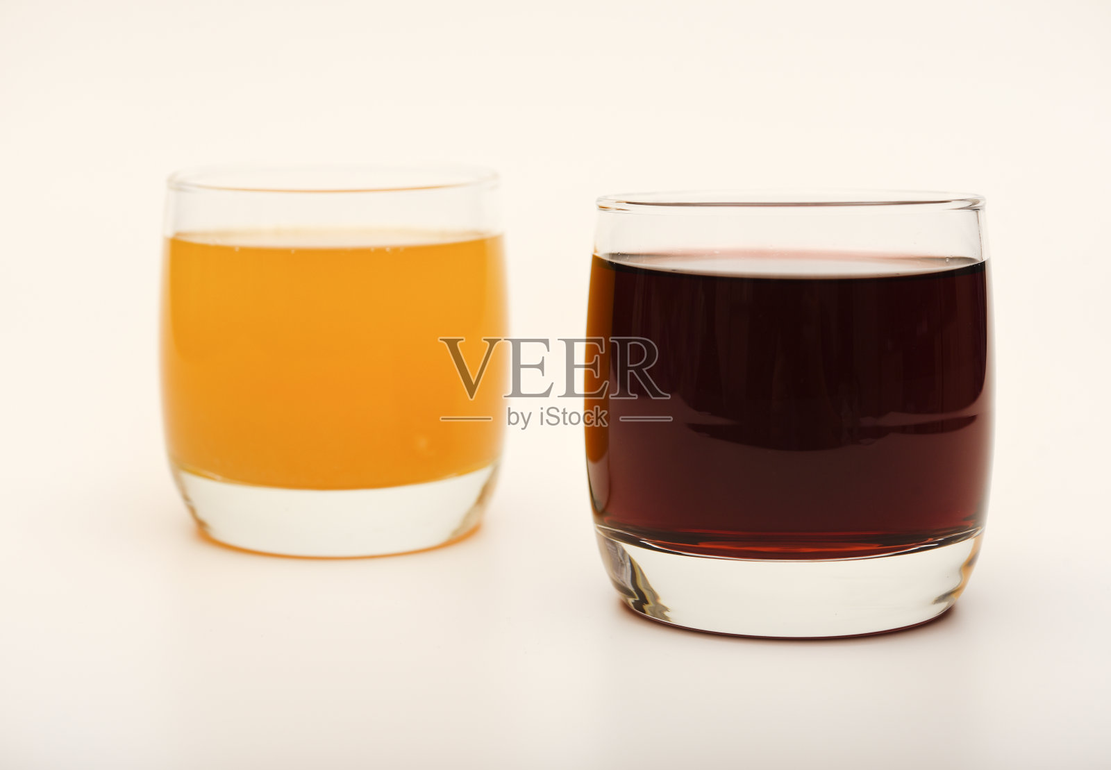 果汁装在白色背景的玻璃杯里。樱桃和橙汁。照片摄影图片