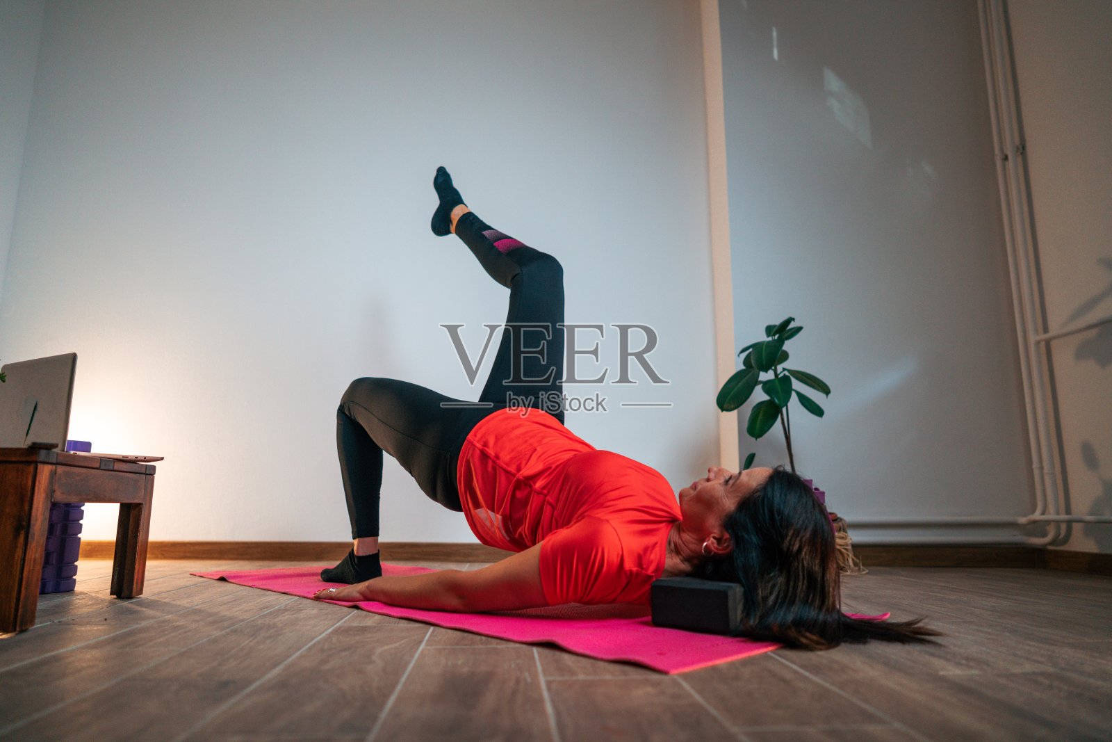 一个快乐的成熟的女人在家做瑜伽照片摄影图片