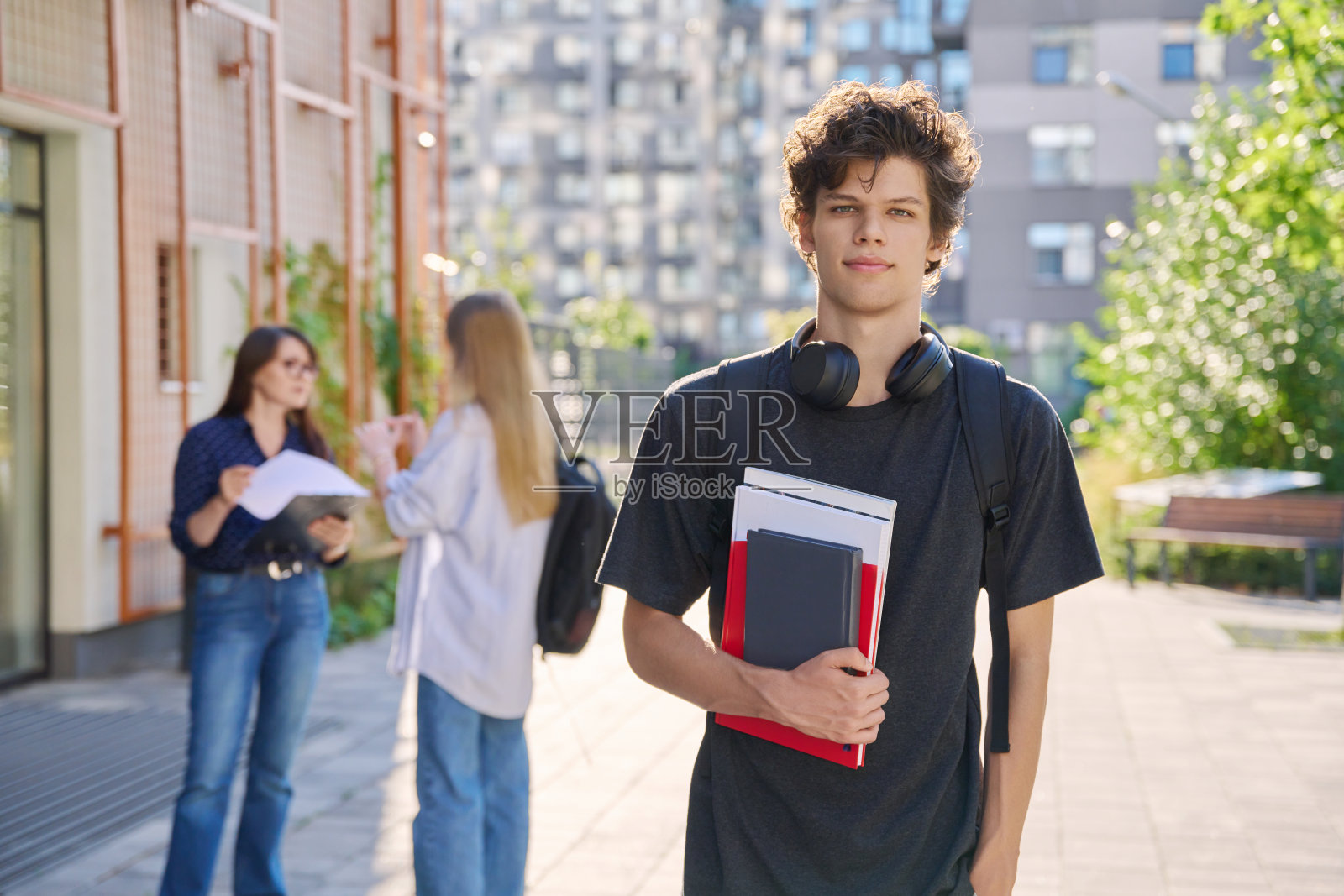 一名大学生在教育大楼附近的户外看着相机的肖像照片摄影图片