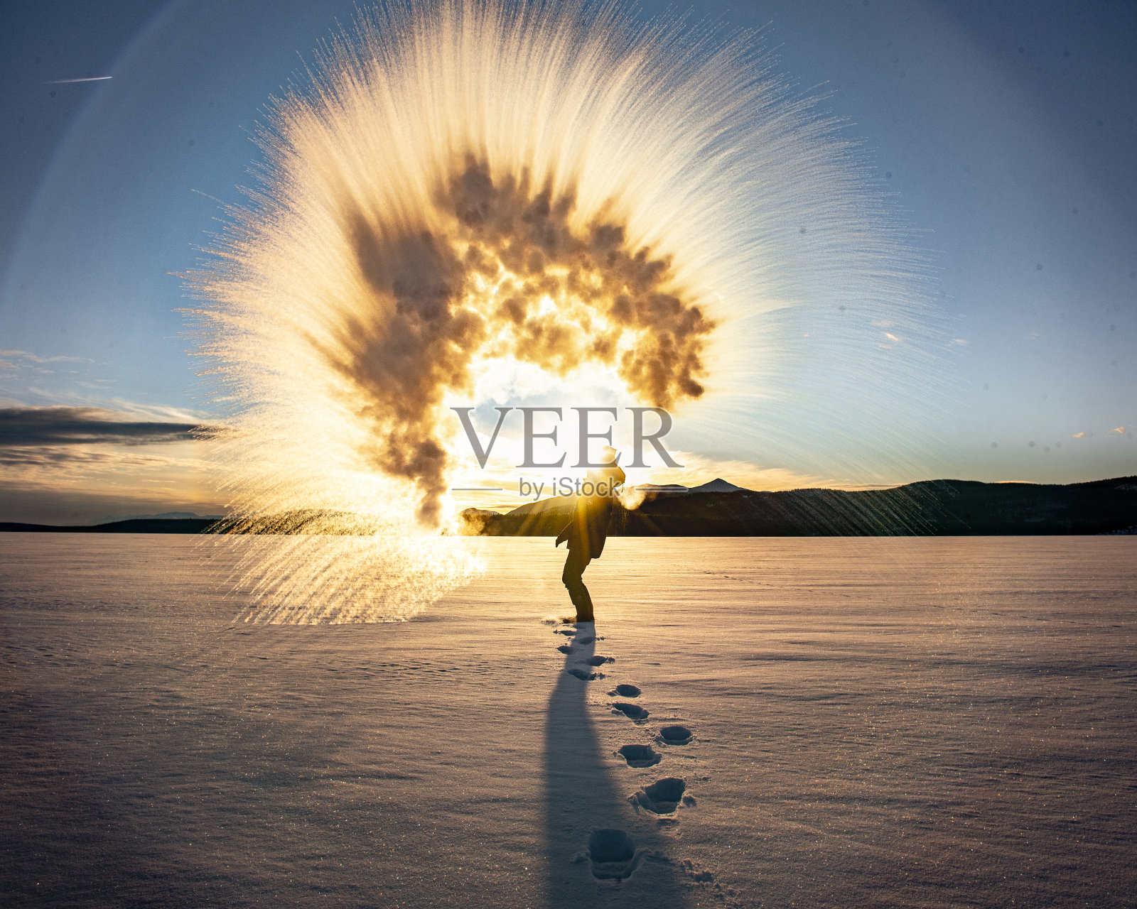 在加拿大北部育空地区的深冬，一名男子在零下40摄氏度的高温下向空中投掷沸水。照片摄影图片