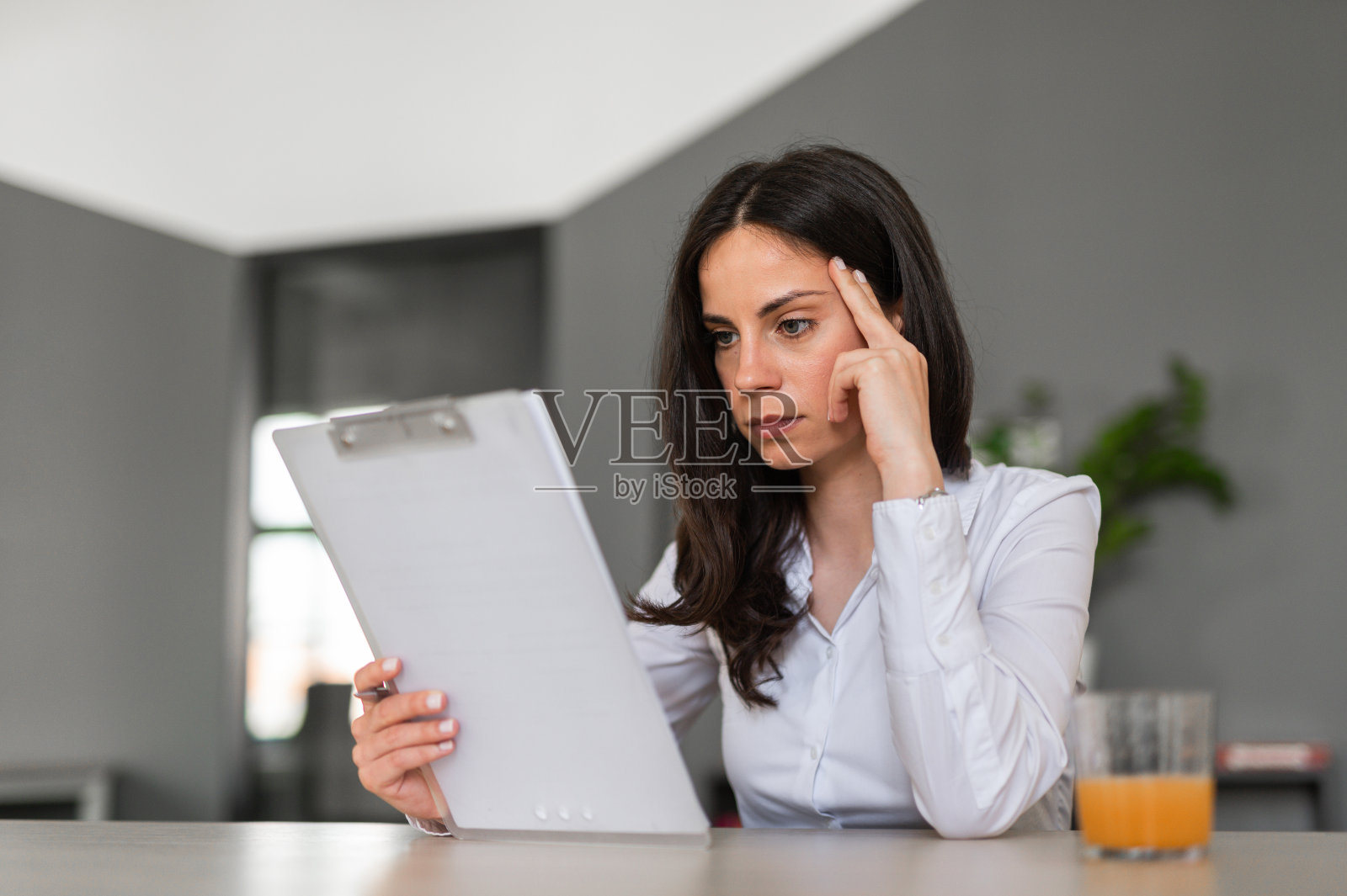 年轻的女企业家专注于在办公桌前阅读文件照片摄影图片