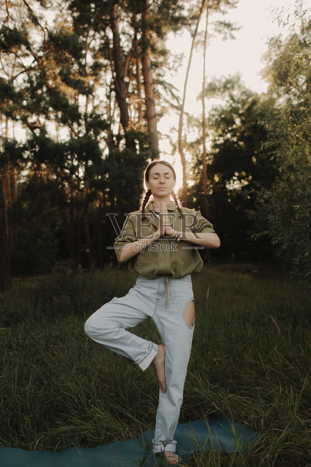 与自然和健康理念的统一。一位兴高采烈的女士在公园里拿着瑜伽垫练习瑜伽。女性理念和健康自然的生活方式。本系列的一部分照片摄影图片