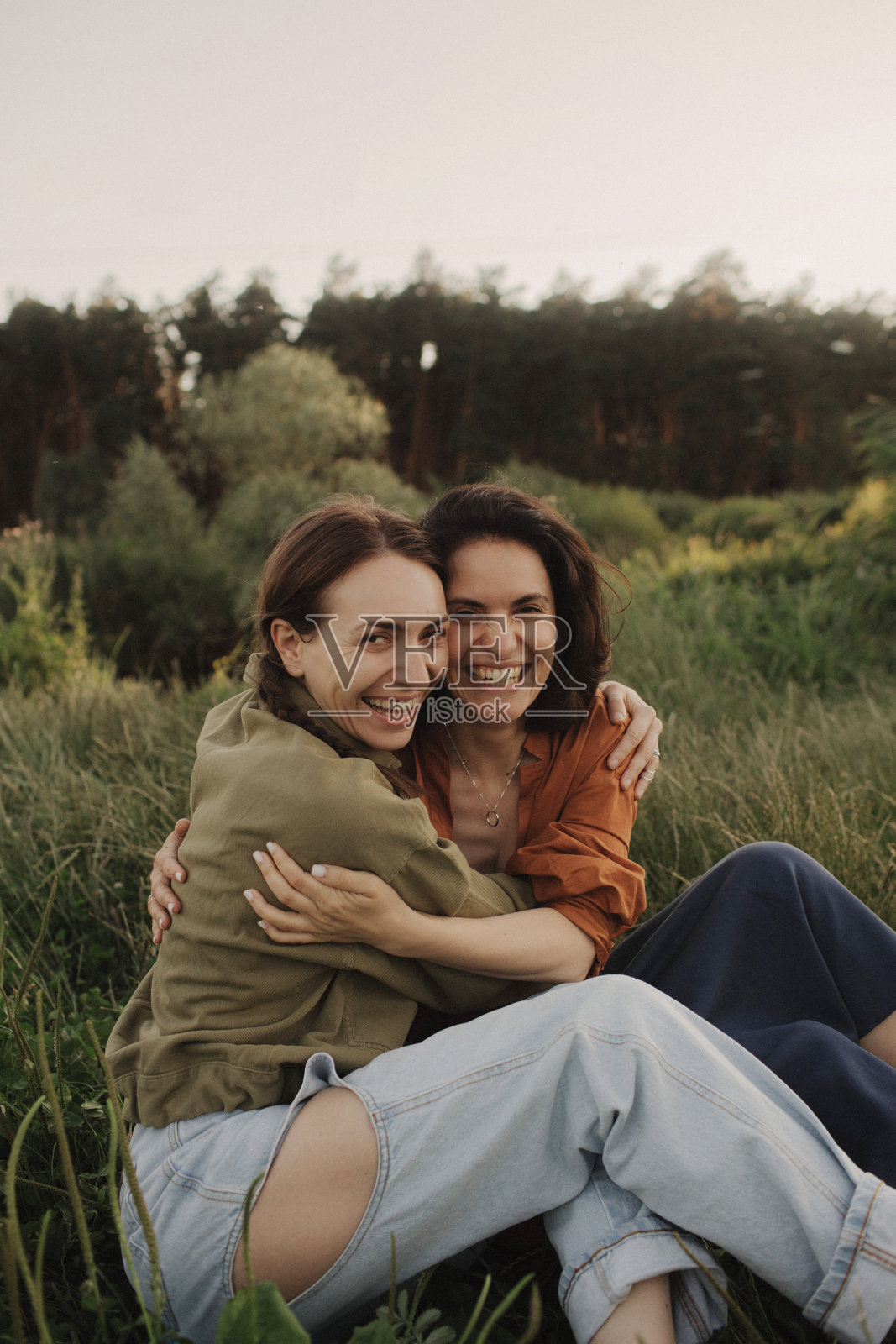 两个快乐的年轻白人女人在森林里度假。欢快美丽的z世代女孩拿着手机摆姿势拍照。坚强的女性友谊。本系列的一部分。照片摄影图片