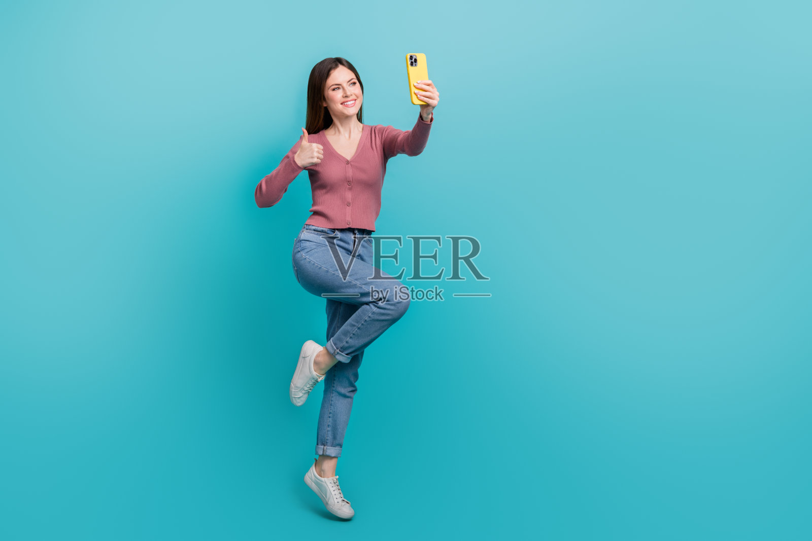 全身跳动的干部无忧无虑的女孩博主大拇指自拍肖像推荐新事件孤立的海蓝宝石色背景照片摄影图片