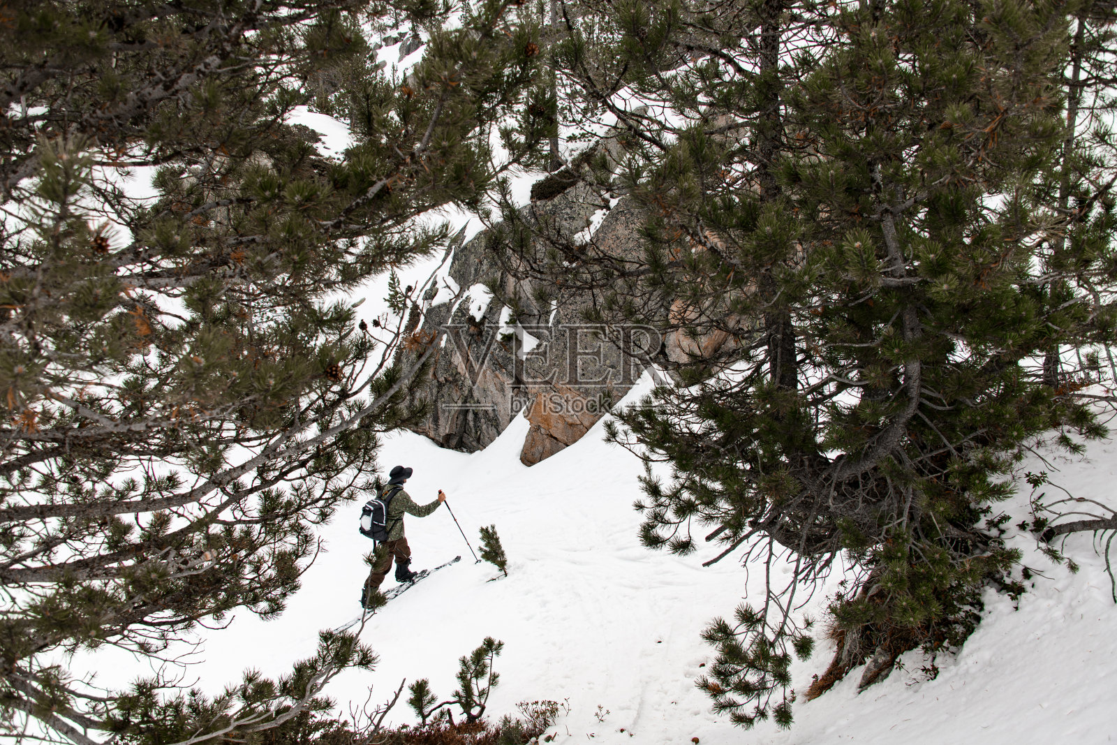 一个滑雪者向上的高角度，试图绕过下一个巨石照片摄影图片