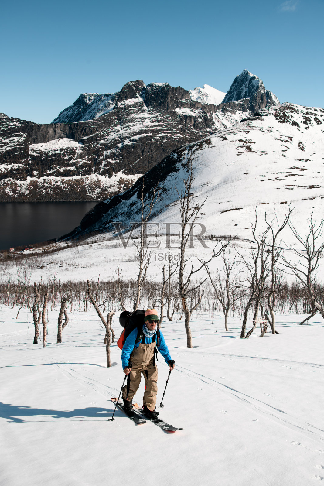 春山，河水流过。一名滑雪者向照相机滑行照片摄影图片