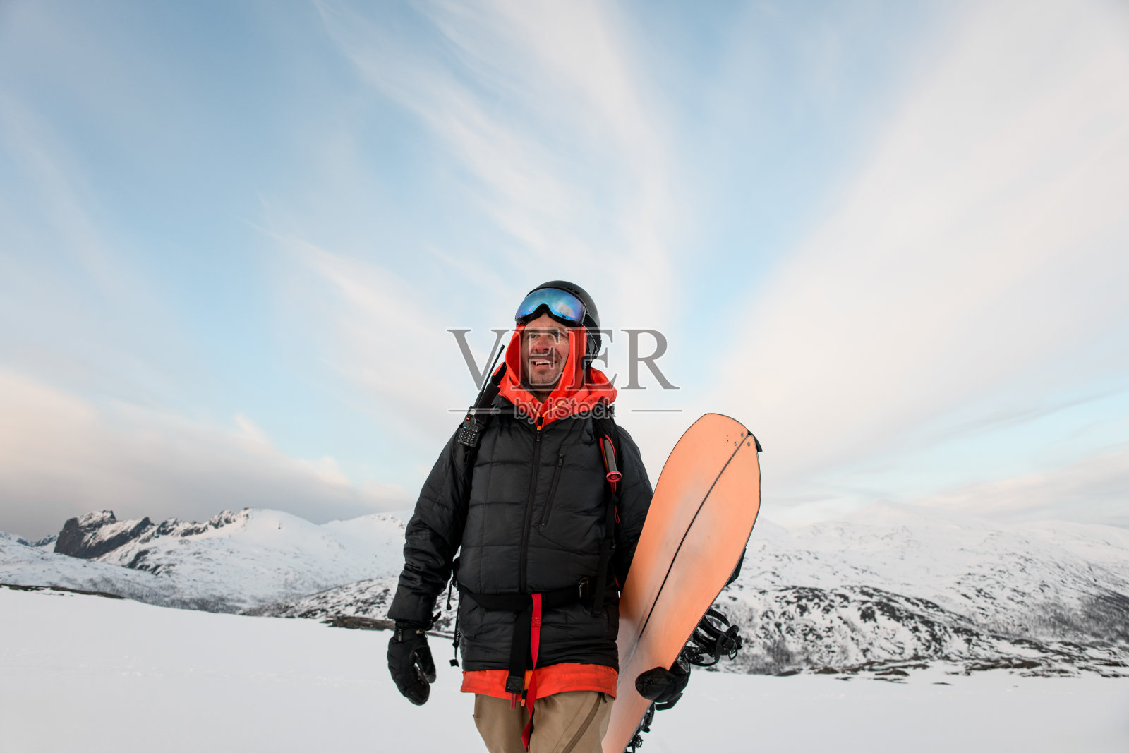 快乐微笑的劈板手，额头上举着眼镜，拿着他的橙色劈板照片摄影图片