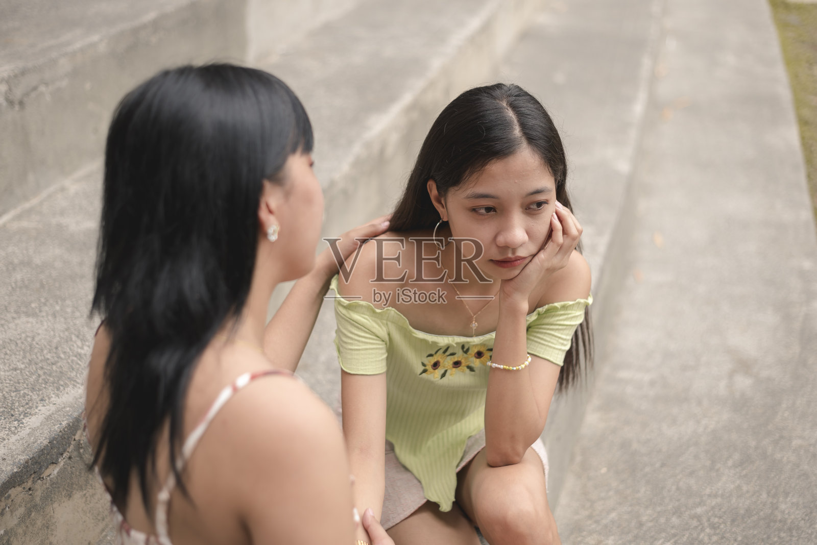 朋友安慰悲伤的年轻女子，倾听她的烦恼照片摄影图片