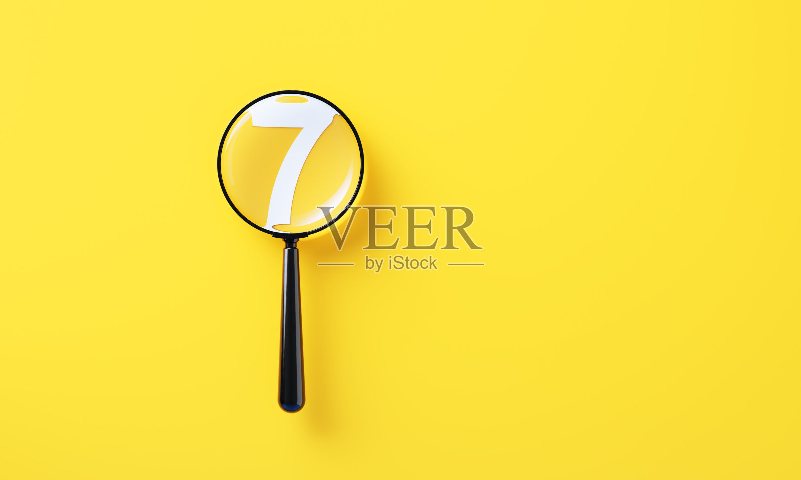 黑色放大镜和黄色背景上的白色七号照片摄影图片