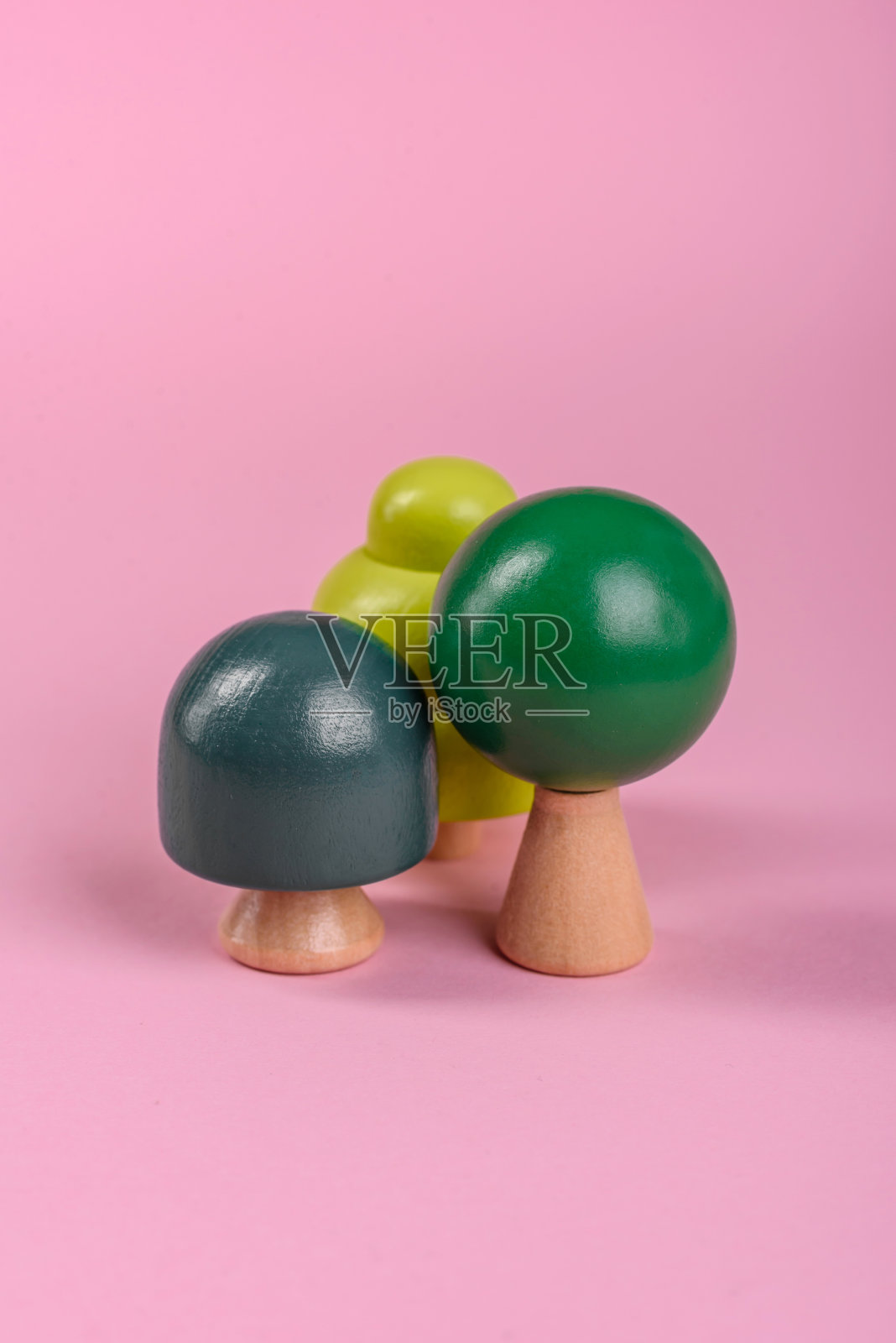 木模型的树与绿色的树冠和树干在粉红色的背景照片摄影图片