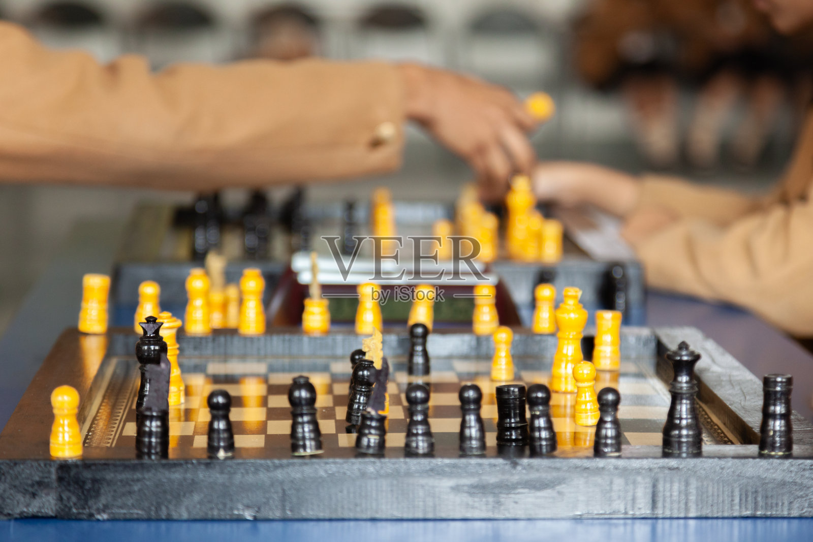 学生们在学校体育活动室下棋，突出战略思维和脑力锻炼。照片摄影图片