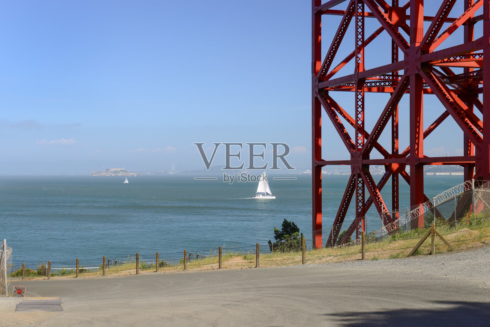 金门大桥的钢塔，白色的船在水中航行。旧金山。加州。照片摄影图片